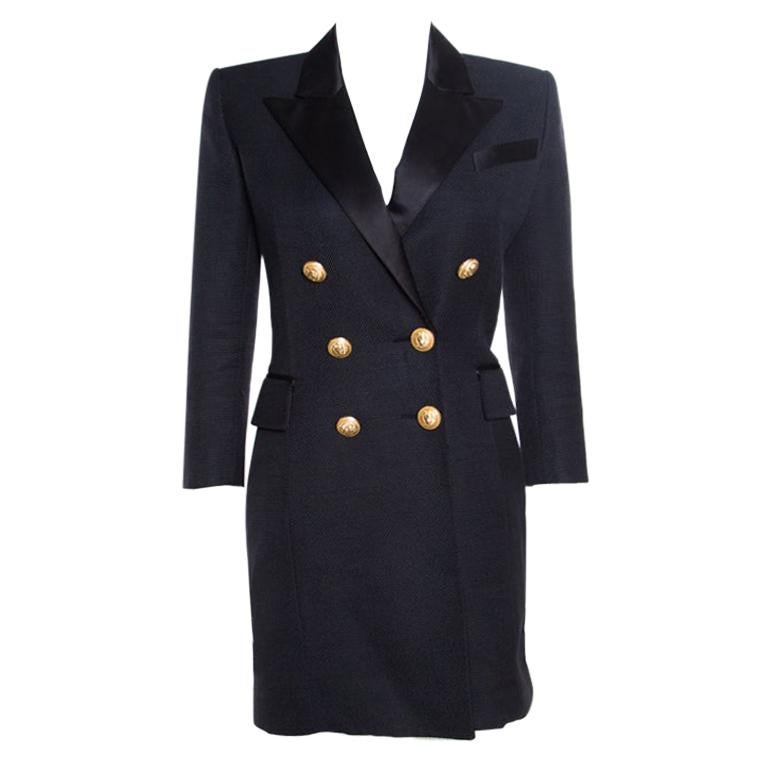 All of Balmain's designs have an edge that resonates with the fashion tastes of the modern world. This coat dress looks stunning with its blazer-inspired design, satin lapels, six gold-tone front buttons, a chest pocket, and twin flap pockets. The