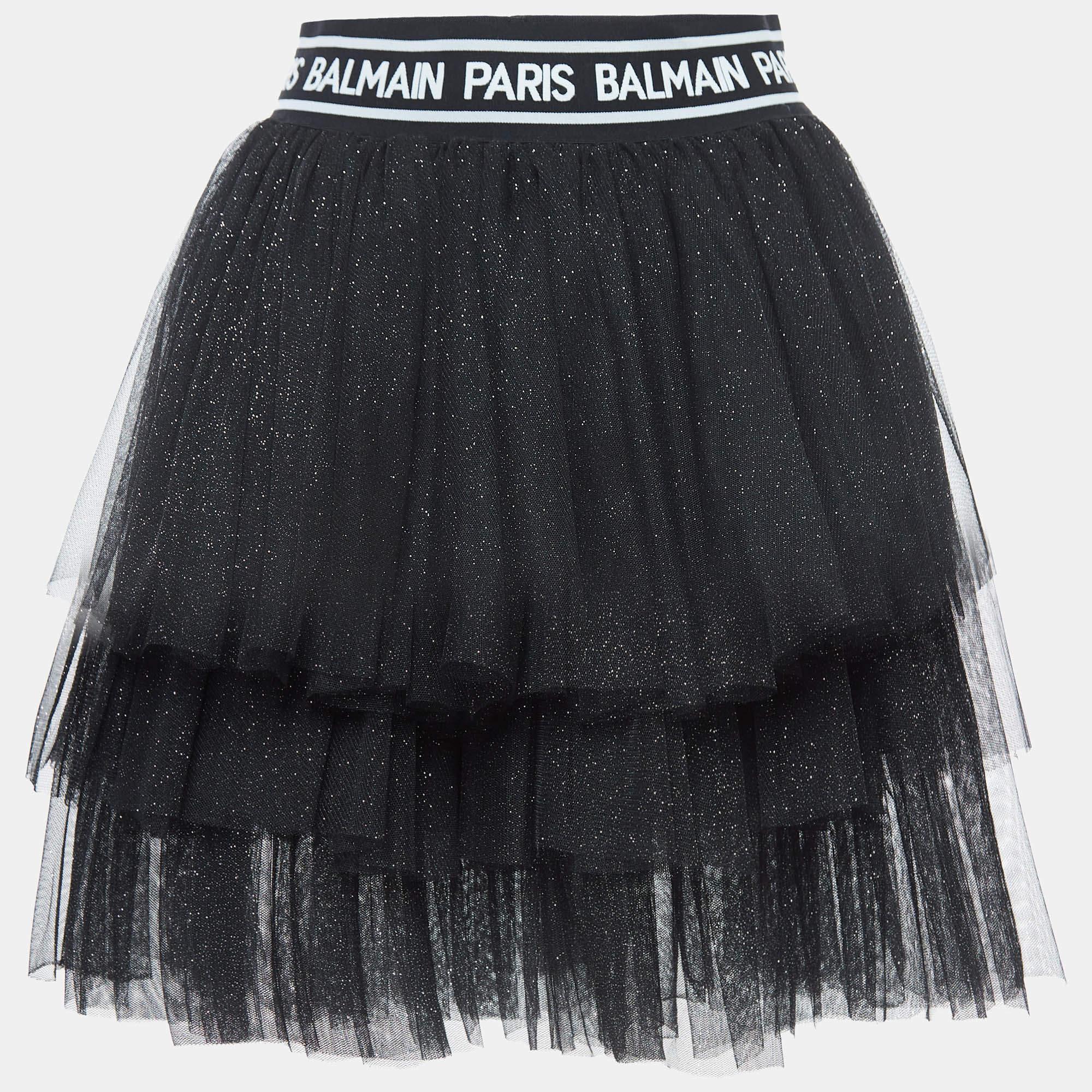 The Balmain skirt is a charming and stylish garment. Crafted with shimmering pink fabric the tiered tulle layers add a playful touch. This cute skirt showcases Balmains iconic design creating a delightful and fashionable addition to any little ones