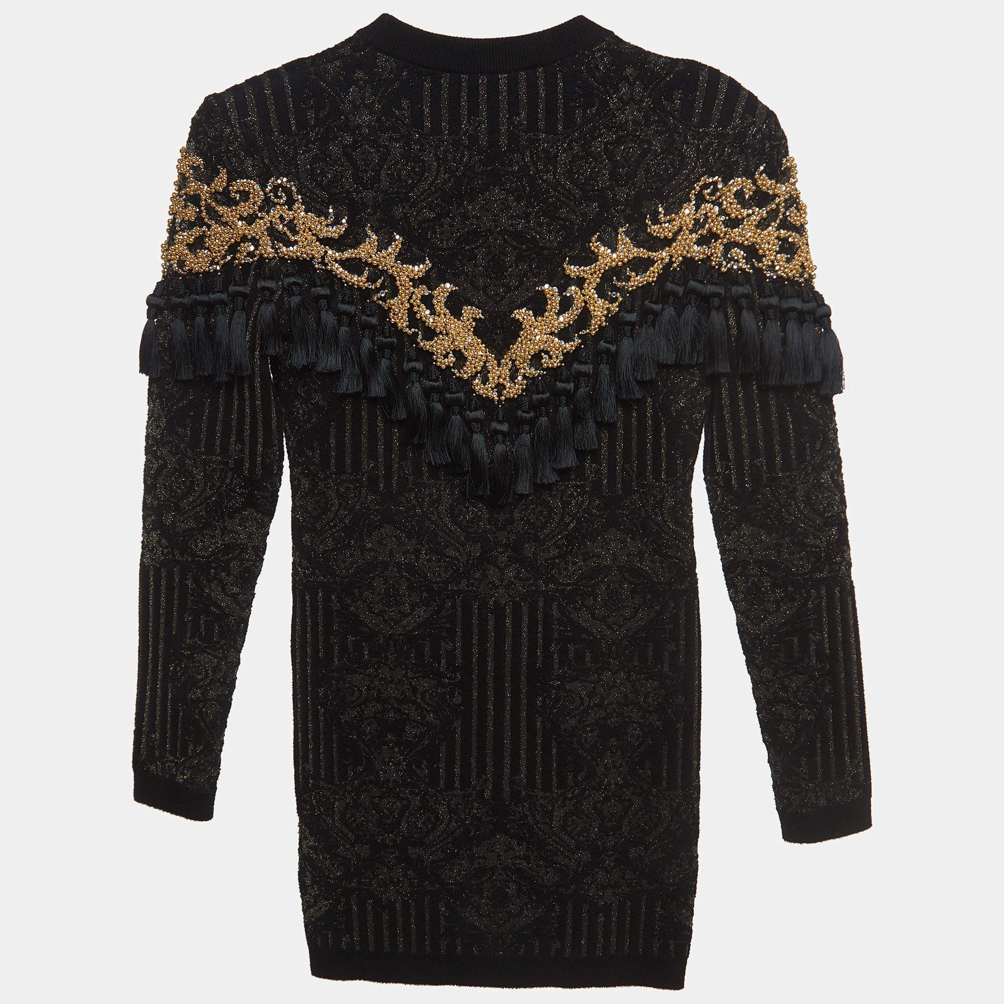 Meticulosamente elaborado, el vestido Balmain combina una construcción meticulosa con un encanto intemporal. El intrincado punto jacquard y los elegantes detalles de borlas crean una pieza que combina sofisticación con un toque de glamour.