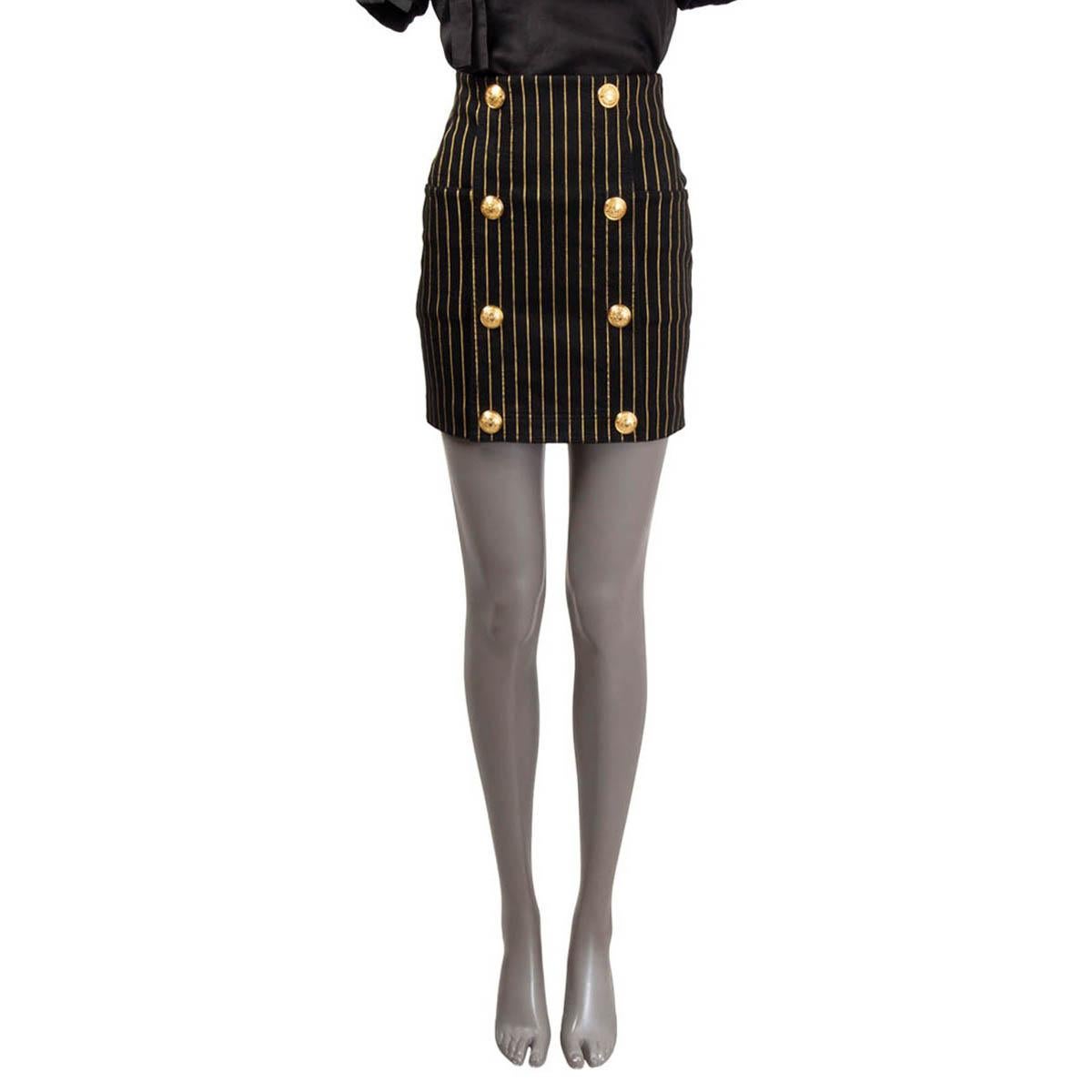 100% authentic Balmain high waisted pinstripe mini skirt in black cotton (98%) and elastane (2%). The design showcases large engraved decorative gold-tone buttons on the front, giving the piece that classic Balmain feel. Side slit pockets and a