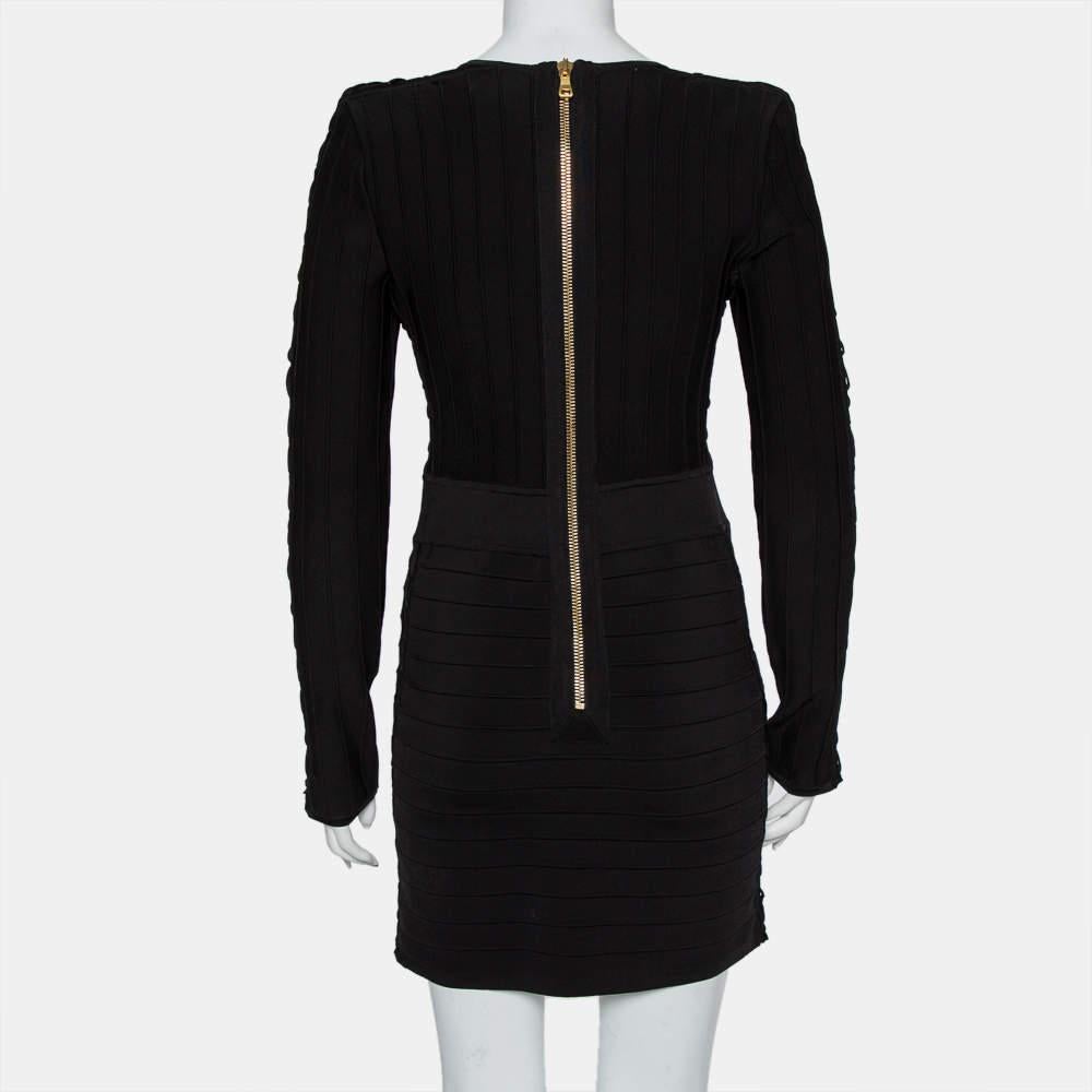 This Balmain black mini dress is a statement-making choice. It's sewn using knit fabric and designed with lace-up details along the V neckline, long sleeves, and back zip closure. The dress can be styled with both pumps, booties, and sandals.

