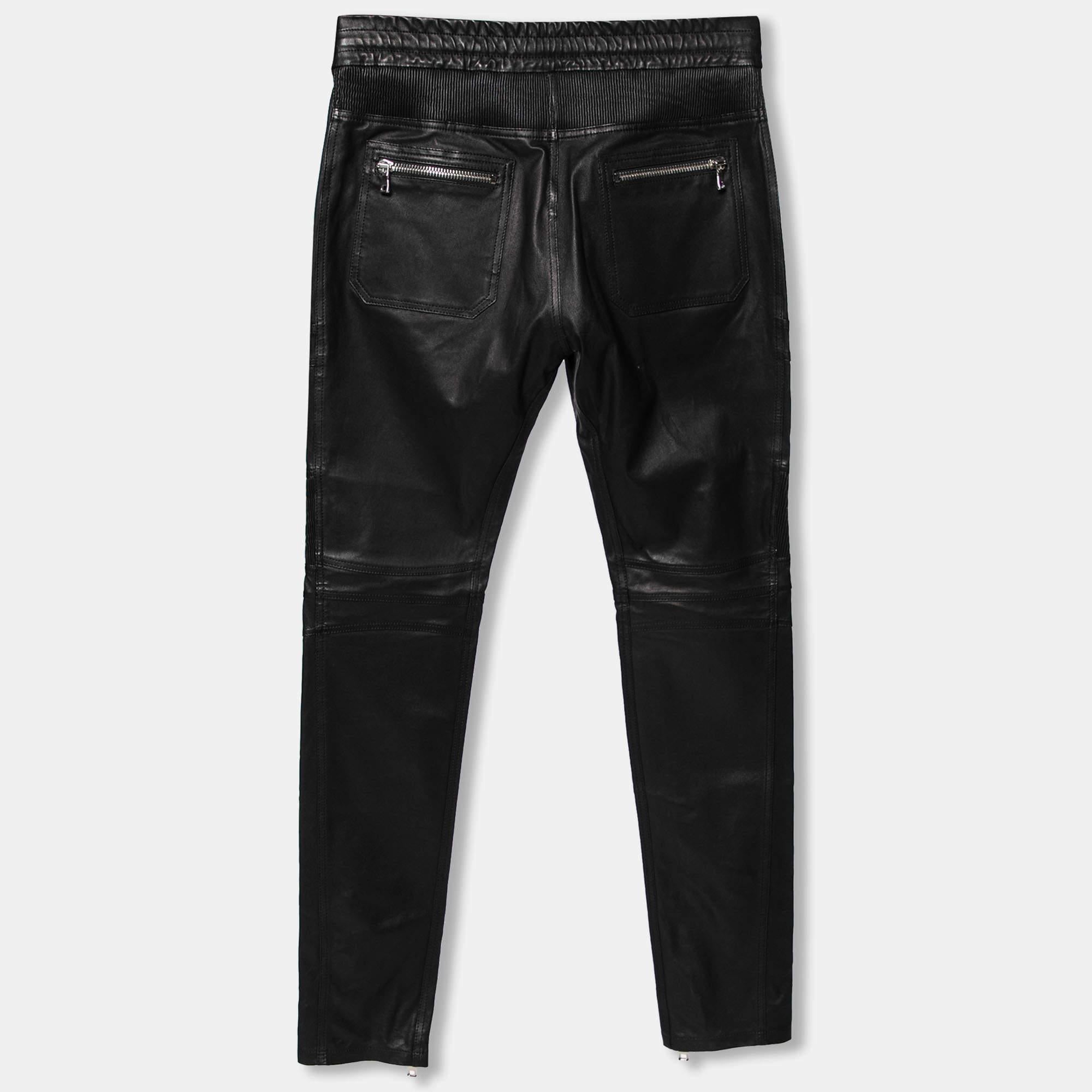 These Biker pants from Balmain will add a luxe edge to your attire. They are created using black leather into a fitted silhouette. They show zipper details. They are equipped with a drawstring closure and an elasticized waist. Add them to your