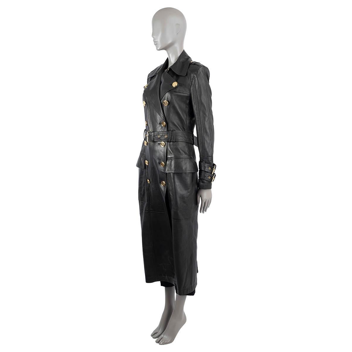 100% authentic Balmain double-breasted trench coat in black lambskin leather (100%). Features a tailored midi length silhouette, gold-tone B logo buttons, two flap pockets on the front, two belt straps on each cuff and a belt. Lined in viskose (52%)