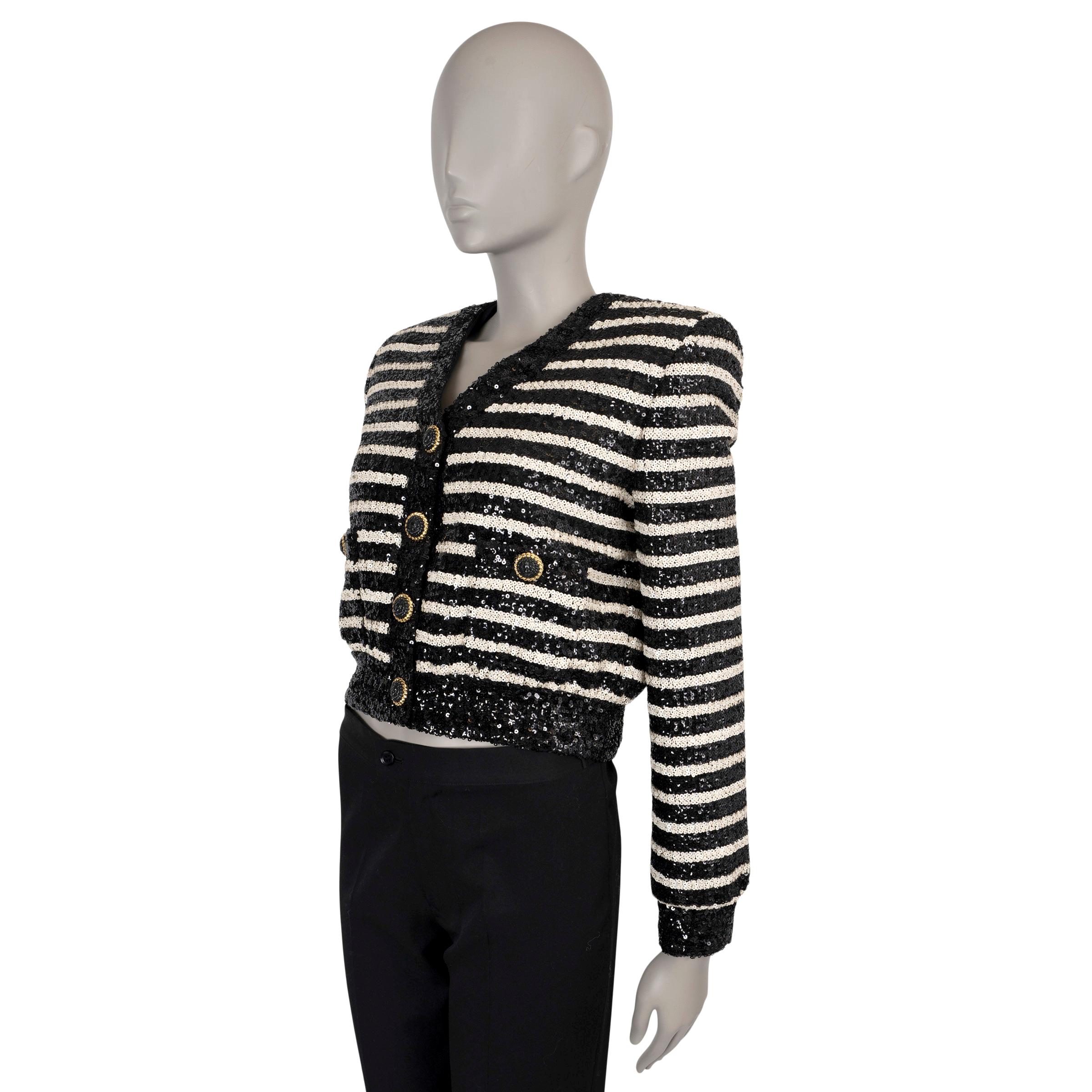 This 100% authentic Balmain jacket in black and cream striped sequins offers a bold, statement-making style. Featuring a cropped silhouette with structured shoulders, a V-neck, and two buttoned pockets, it combines glamour with Balmain’s signature