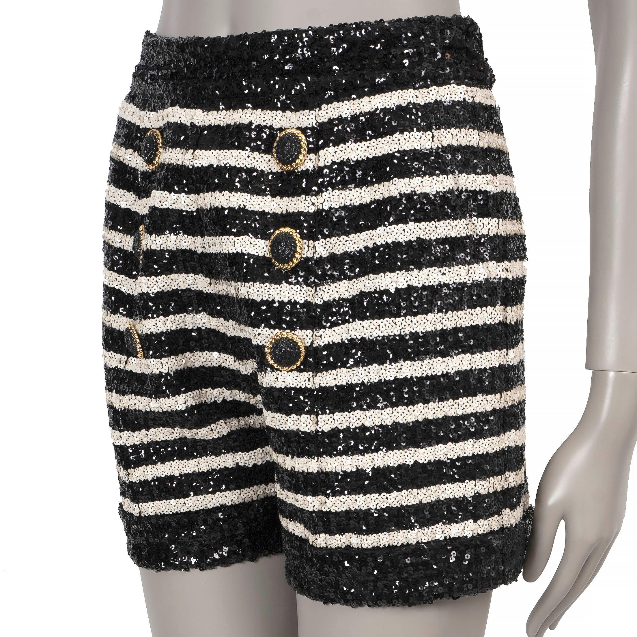 These 100% authentic Balmain mini shorts in black and cream striped sequins bring a glamorous edge to any outfit. Featuring a high waist with slant pockets and a double row of decorative lion head buttons on the front, they exude Balmain’s signature