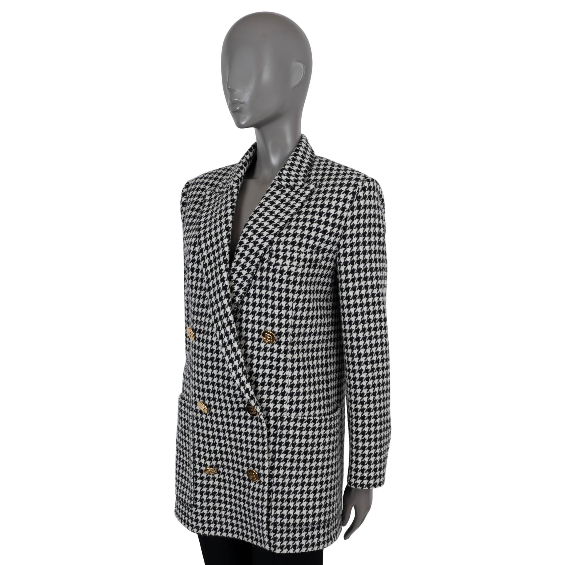 100% autentico blazer doppiopetto Balmain in lana pied de poule bianca e nera (79%), nylon (15%), angora (5%) e poliammide (1%). Presenta una silhouette oversize e squadrata, revers a lancia, una tasca sul petto e due tasche applicate in vita. Si