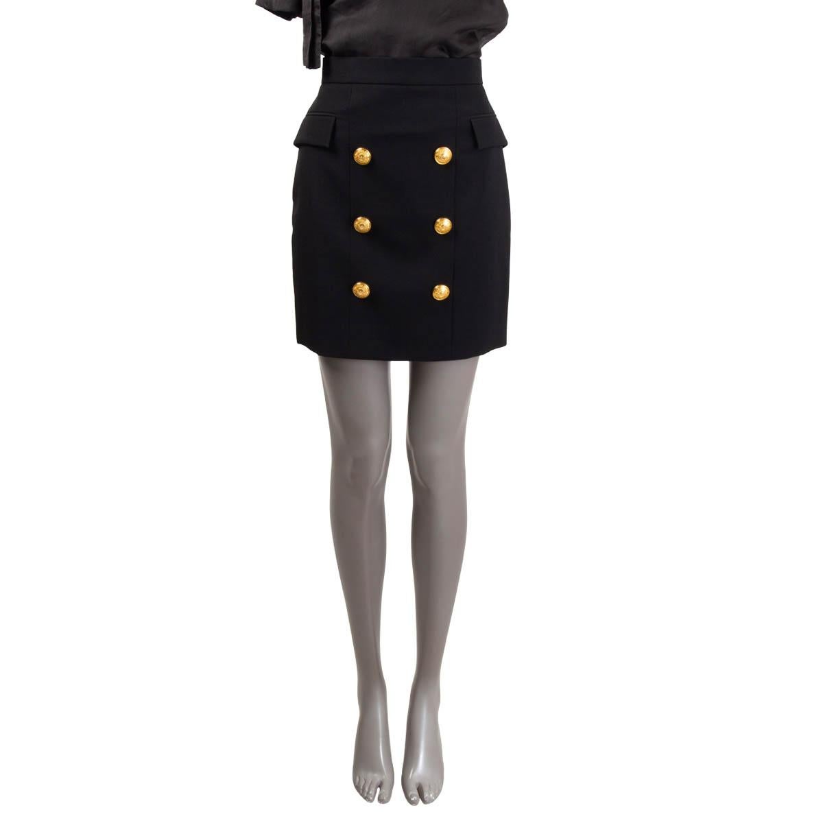 100% authentic Balmain high waisted mini skirt in black wool (100%). The design showcases large engraved decorative gold-tone buttons on the front, giving the piece that classic Balmain feel. Side flap pockets and a gold-tone metal zip fastening at