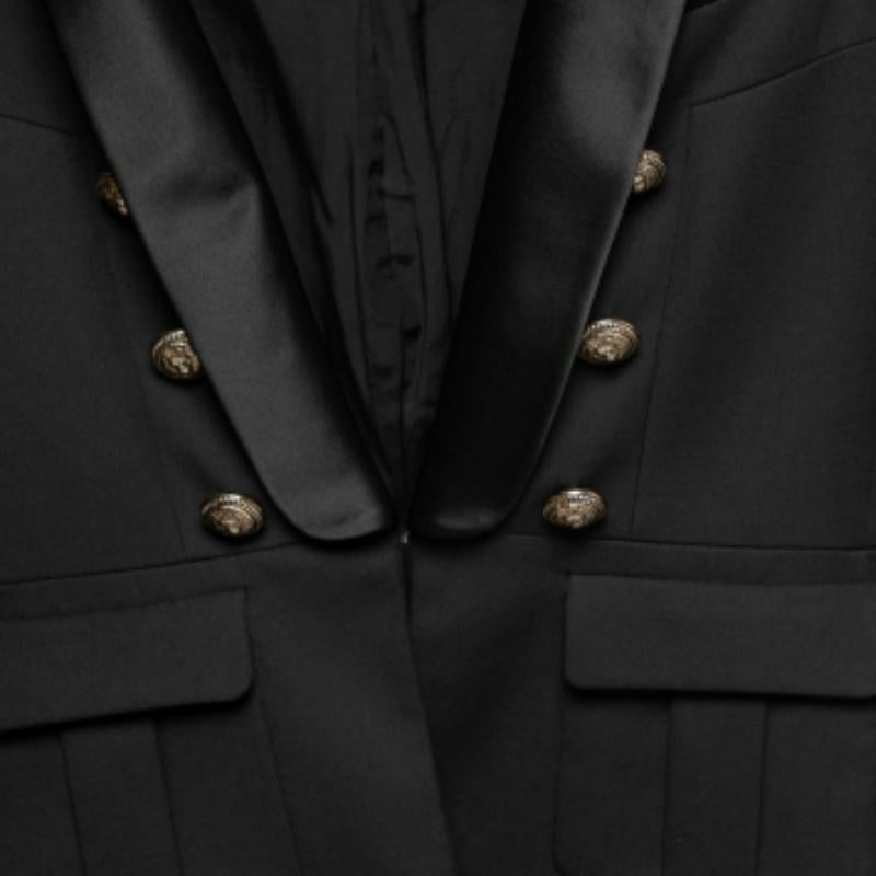 La sartoria impeccabile di Balmain è ineguagliabile e questo blazer ne è l'esempio. Realizzata in lana, questa creazione è di colore nero ed è ornata da bottoni argentati. Le spalle strutturate degli iconici blazer Balmain li rendono così