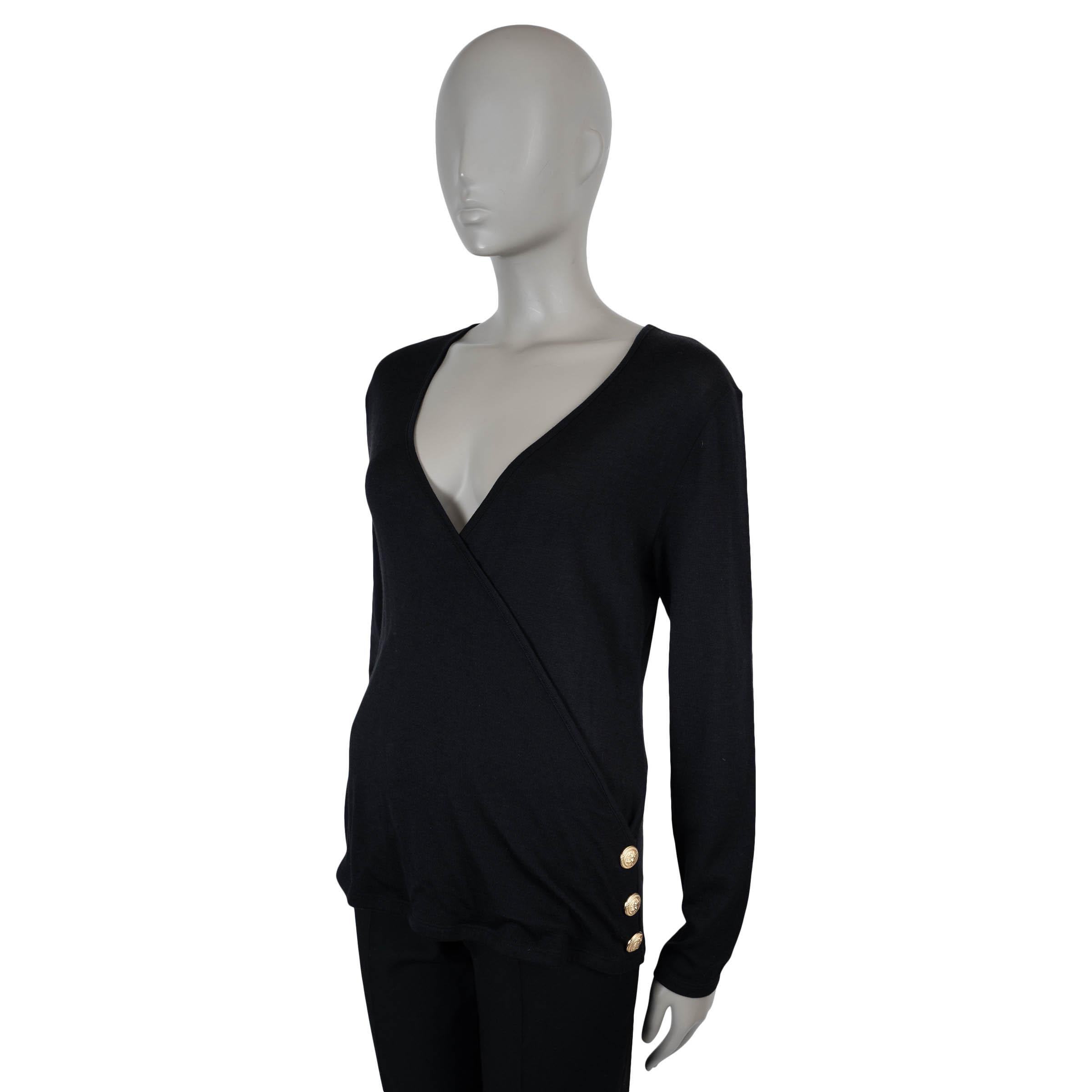 Ce pull en laine (70%) et soie (30%) noire légère, 100% authentique de Balmain, allie une douceur luxueuse aux détails emblématiques de la maison. Doté d'un décolleté en V profond et d'une silhouette élégante et ajustée, il est parachevé par trois