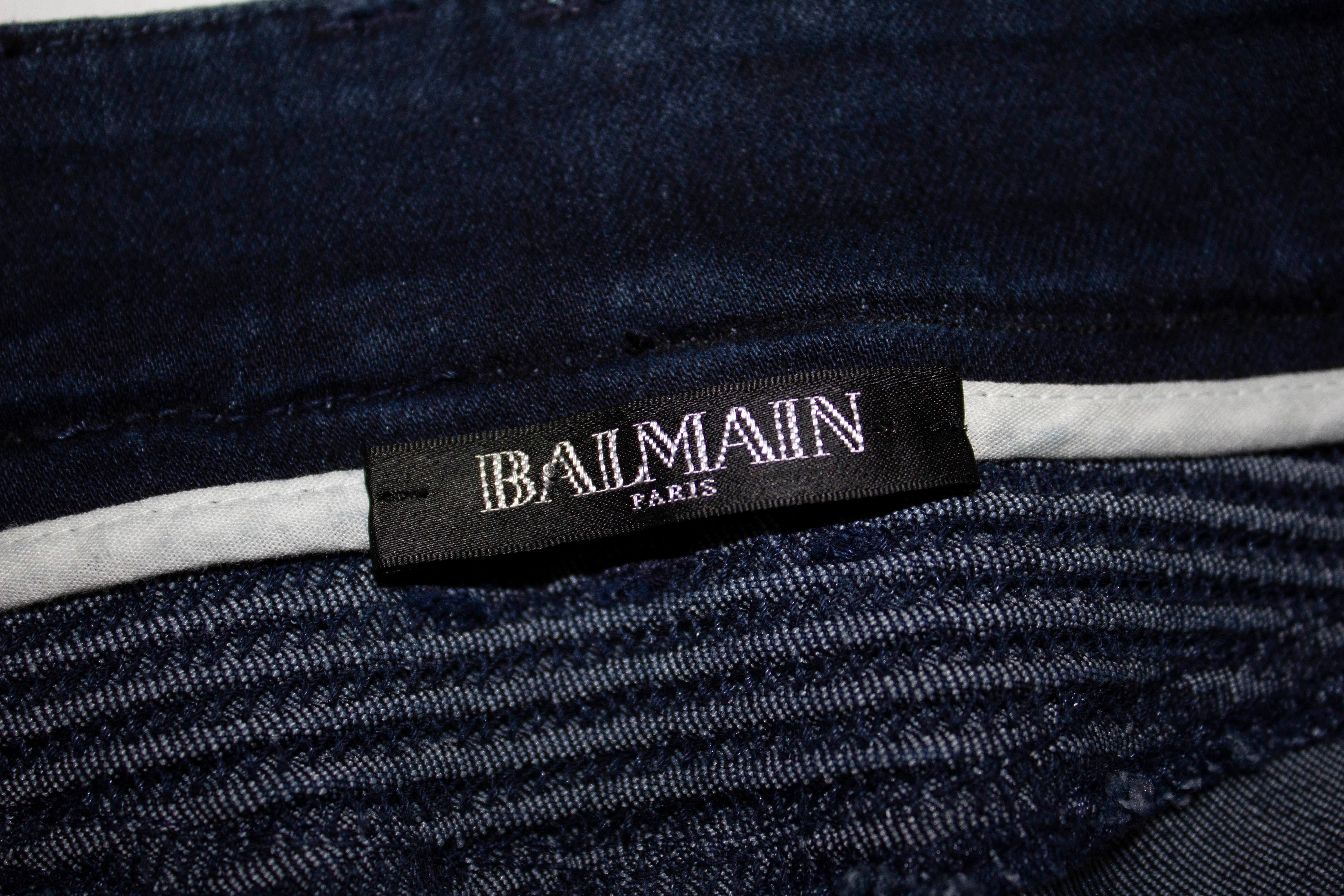 A chic pair of blue jeans by Balmain. They have a zip fly with a button over flap and 8'' zip on the inside leg at base. Marked size 34, waist 26'', inside leg 32''
