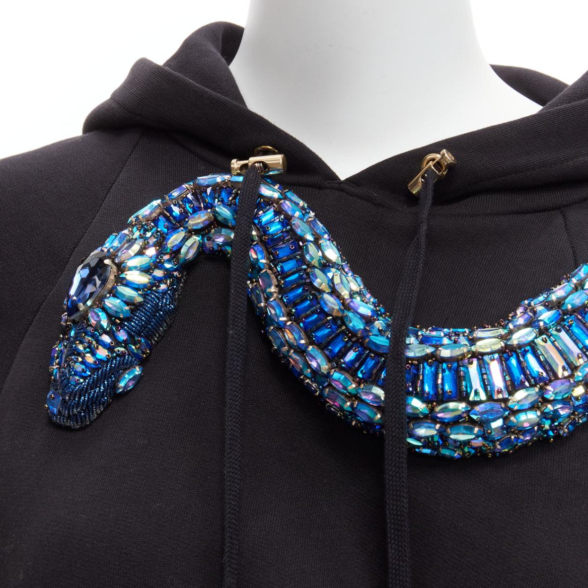 BALMAIN blue jewel embellished snake motif black cotton cropped hoodie XS
Reference: AAWC/A00531
Brand: Balmain
Designer: Olivier Rousteing
Material: Cotton
Color: Black, Blue
Pattern: Solid
Closure: Pullover
Extra Details: Snake-motif embellished