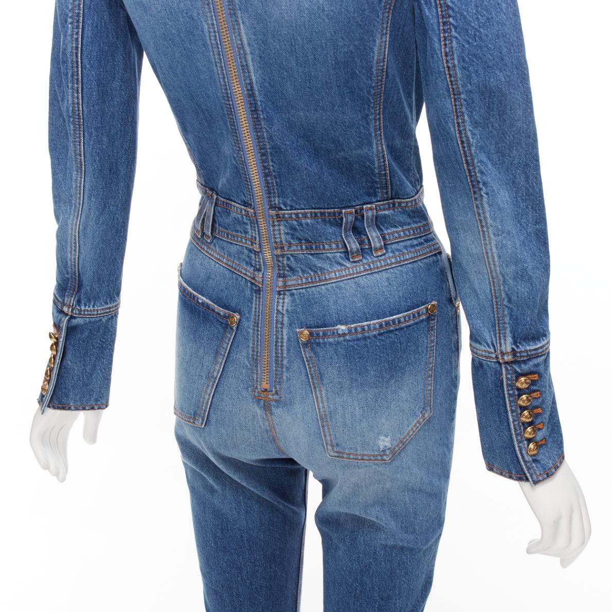 BALMAIN blue washed distressed denim gold double breasted jumpsuit FR34 XS
Reference: AAWC/A00727
Brand: Balmain
Designer: Olivier Rousteing
Collection: 2020
Material: Denim
Color: Blue, Gold
Pattern: Solid
Closure: Zip
Extra Details: Long sleeve
