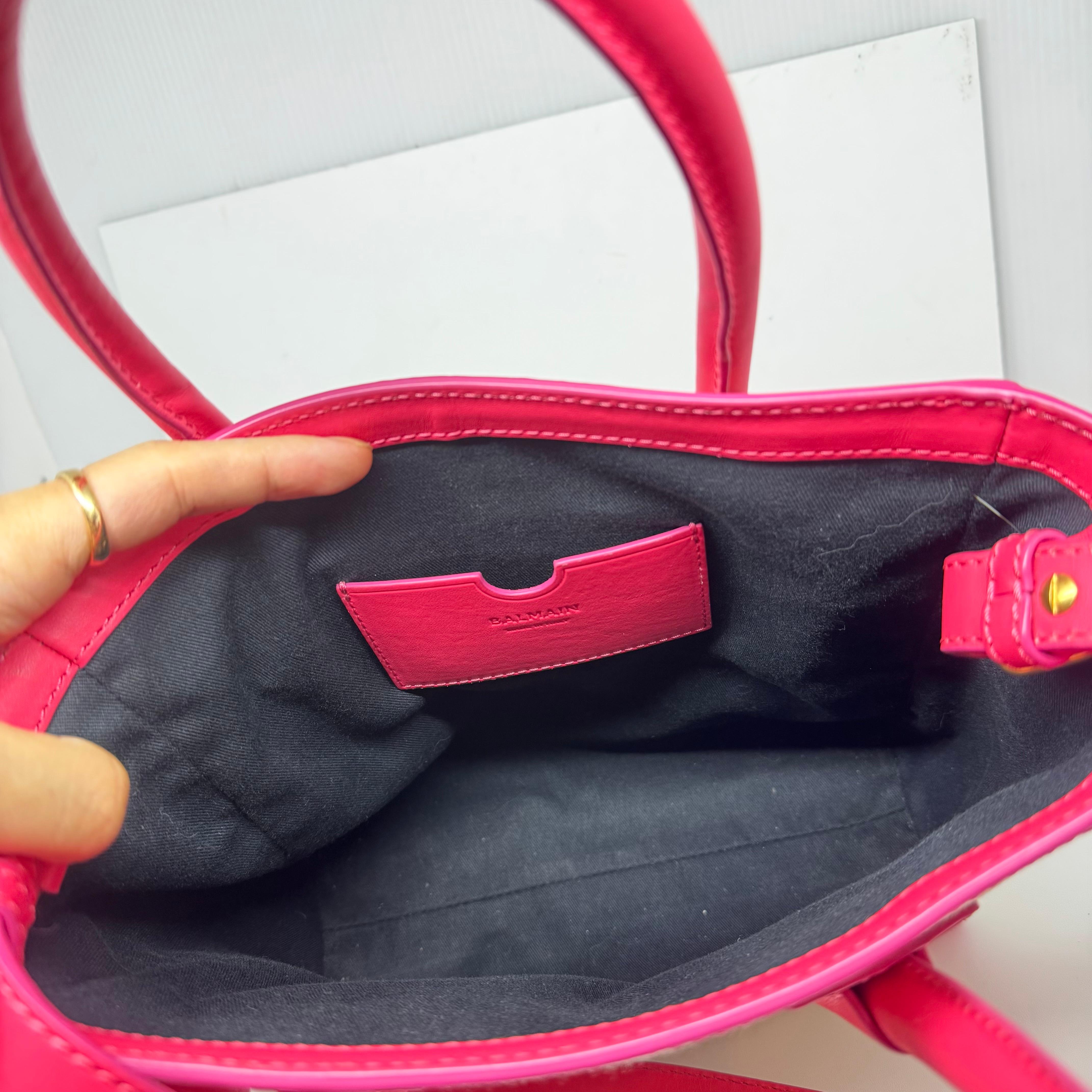 Balmain Canvas-Tasche mit fluoreszierendem rosa Leder. Sehr lässig und doch stilvoll. Sichtbare Schmutzspuren auf den Leinwänden, wie auf den Bildern zu sehen. Mit angebrachtem Trageriemen. Leicht abgenutzt, aber sichtbare Minuspunkte. Wird mit
