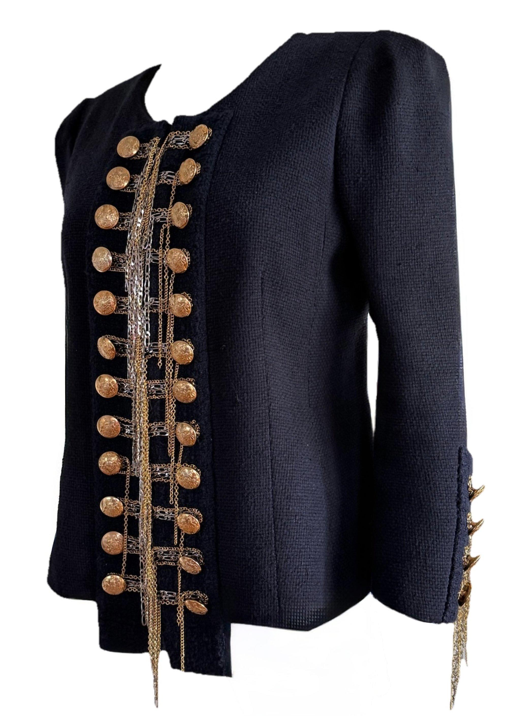 De la colección Otoño/Invierno 2010 de Christophe Decarnin, esta icónica chaqueta Balmain de inspiración militar canaliza su característica estética Baroque 'n' Roll. Muy adornado con detalles de cadenas doradas y plateadas que cuelgan de la tapeta