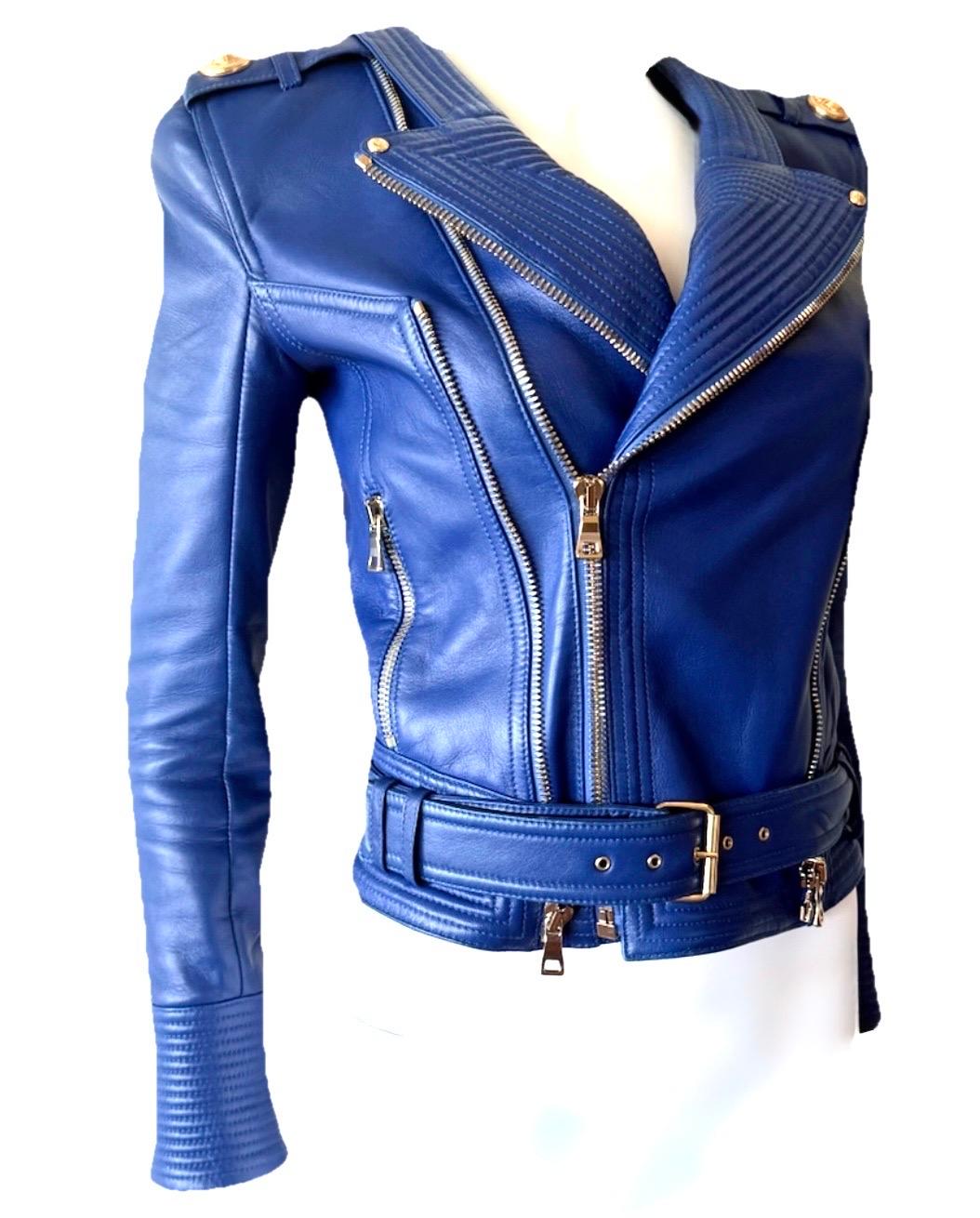 Diese Balmain-Motojacke aus seltenem kobaltblauem Leder ist ein kühnes, wunderschön verarbeitetes Statement-Stück. Sie ist aus geschmeidigem Lammleder gefertigt und mit den markentypischen goldfarbenen Beschlägen und Druckknöpfen mit Logoprägung am