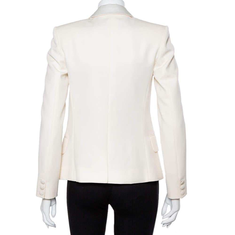 Chic, stylish, and very modern, this blazer from Balmain is a gorgeous piece to flaunt on both casual and evening outings. The fabulous cream blazer is made of wool. It flaunts an open front silhouette, long sleeves, and buttons on the cuffs. Pair