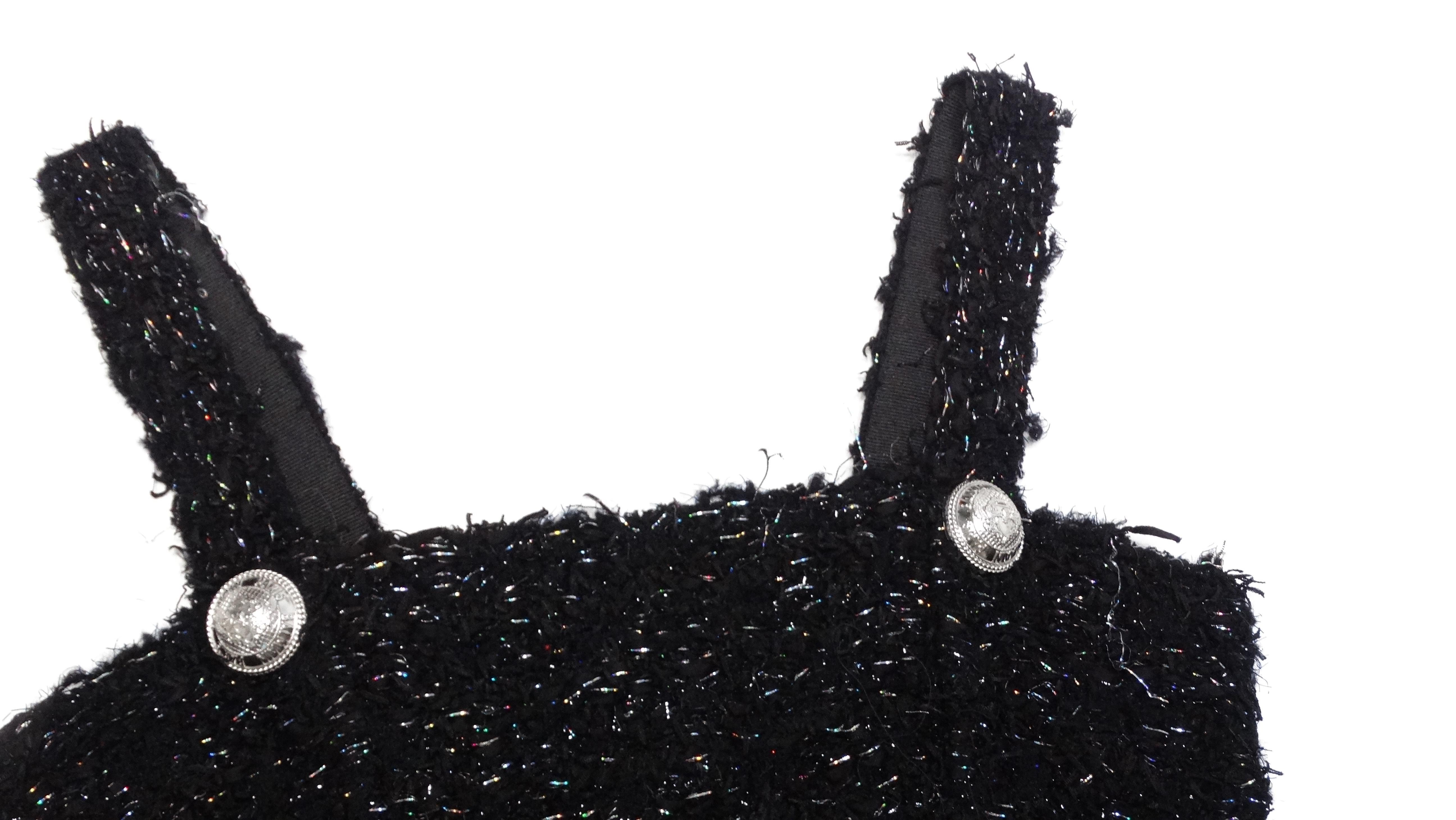 Le top court bustier en tweed noir de Balmain incarne l'élégance intemporelle avec une touche de modernité. Confectionné en tweed noir entrelacé de fibres métalliques arc-en-ciel scintillantes, ce haut dégage un éclat sophistiqué qui passe sans