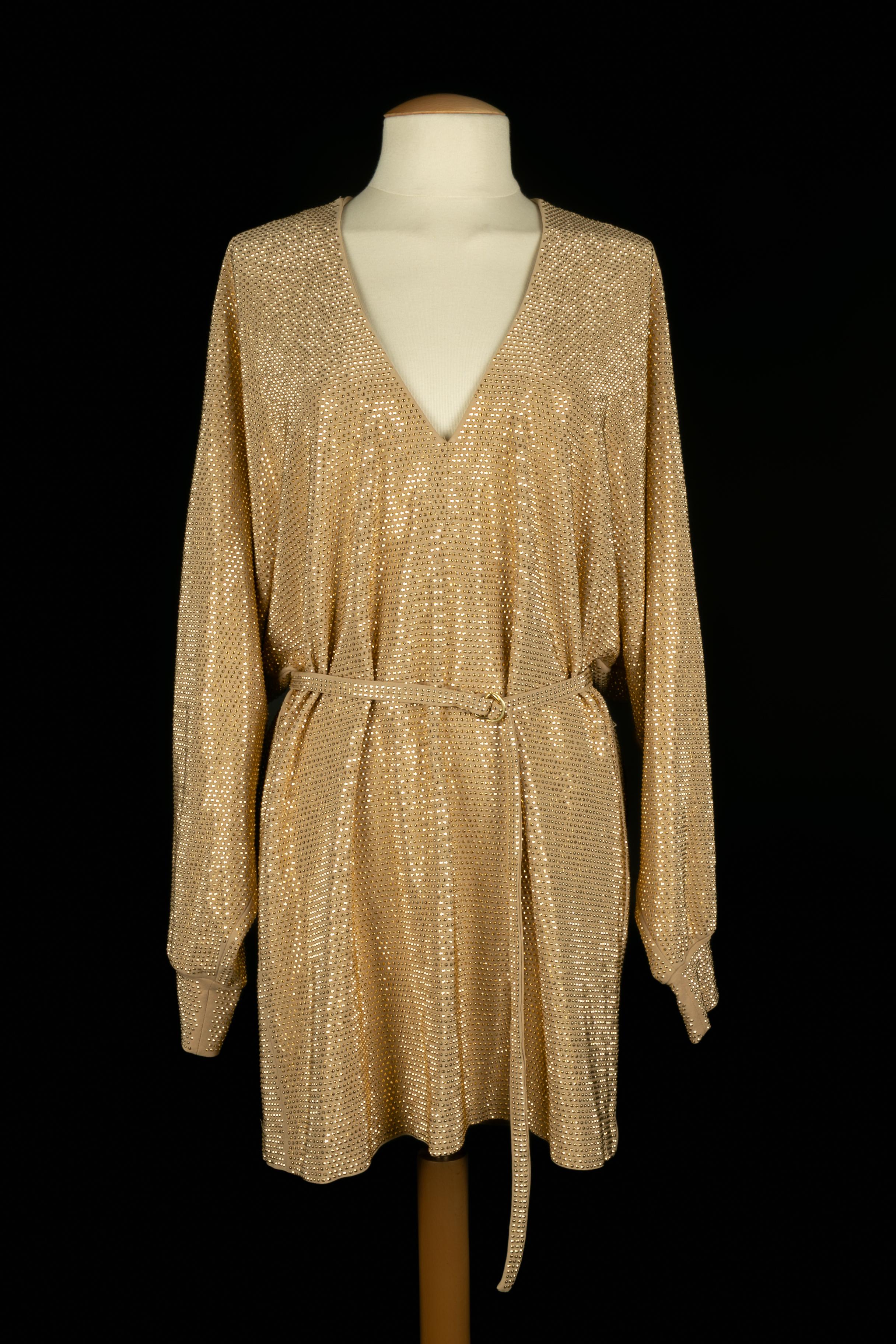 Balmain - (Made in Italy) Abito corto elasticizzato beige ornato da strass dorati. Indicata la taglia 38FR.

Condizioni:
Ottime condizioni

Dimensioni:
Larghezza spalle: 42 cm - Lunghezza maniche: 68 cm - Lunghezza: 88 cm

SKU:VR459