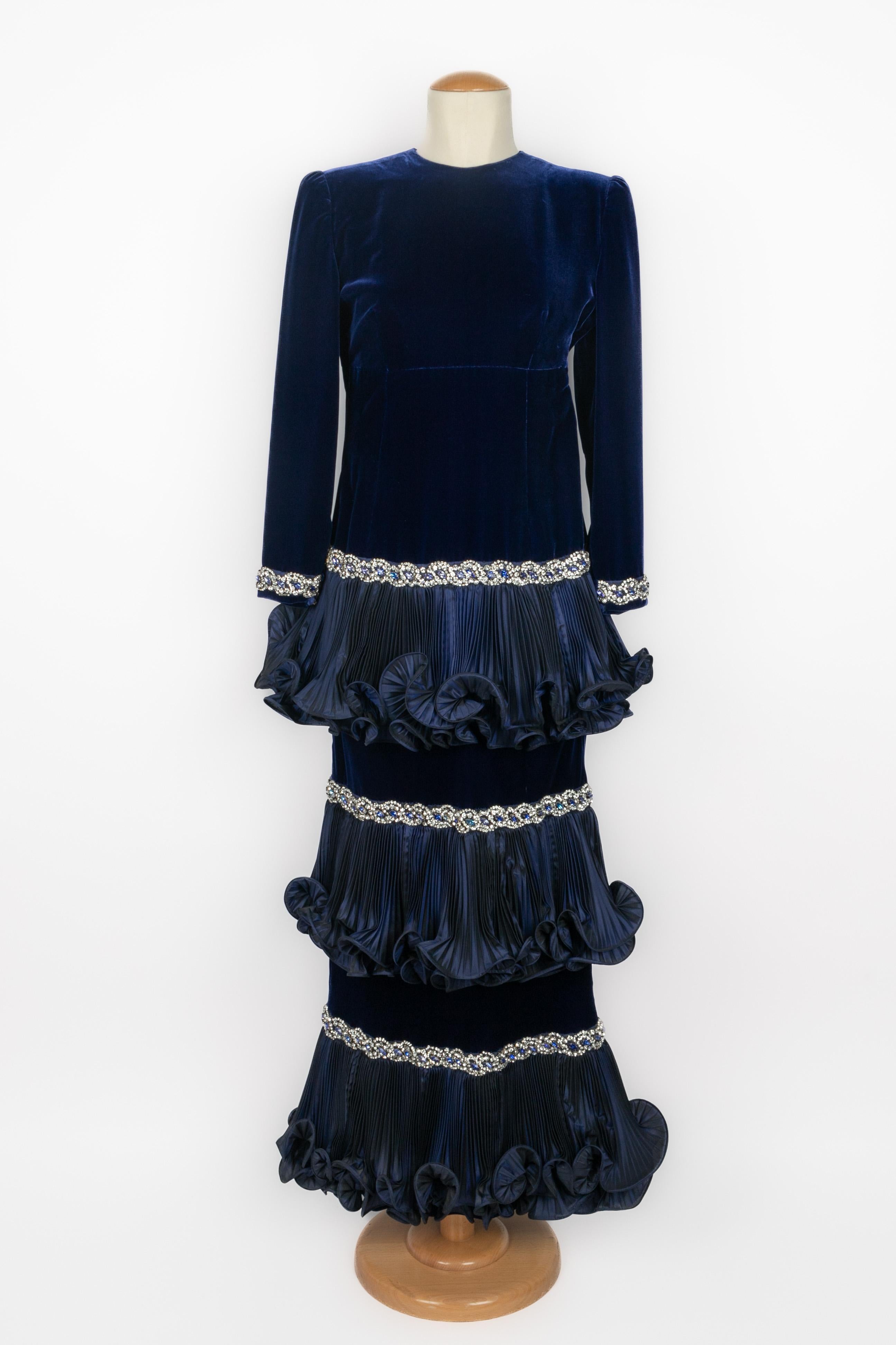 BALMAIN - (Made in France) Long navy-blue silk and velvet dress. Low-rise effect and skirt with pleated flounce layering embroidered with rhinestoned strips. Composition and size labels missing, it fits a 38FR. 1984 Fall-Winter Haute Couture