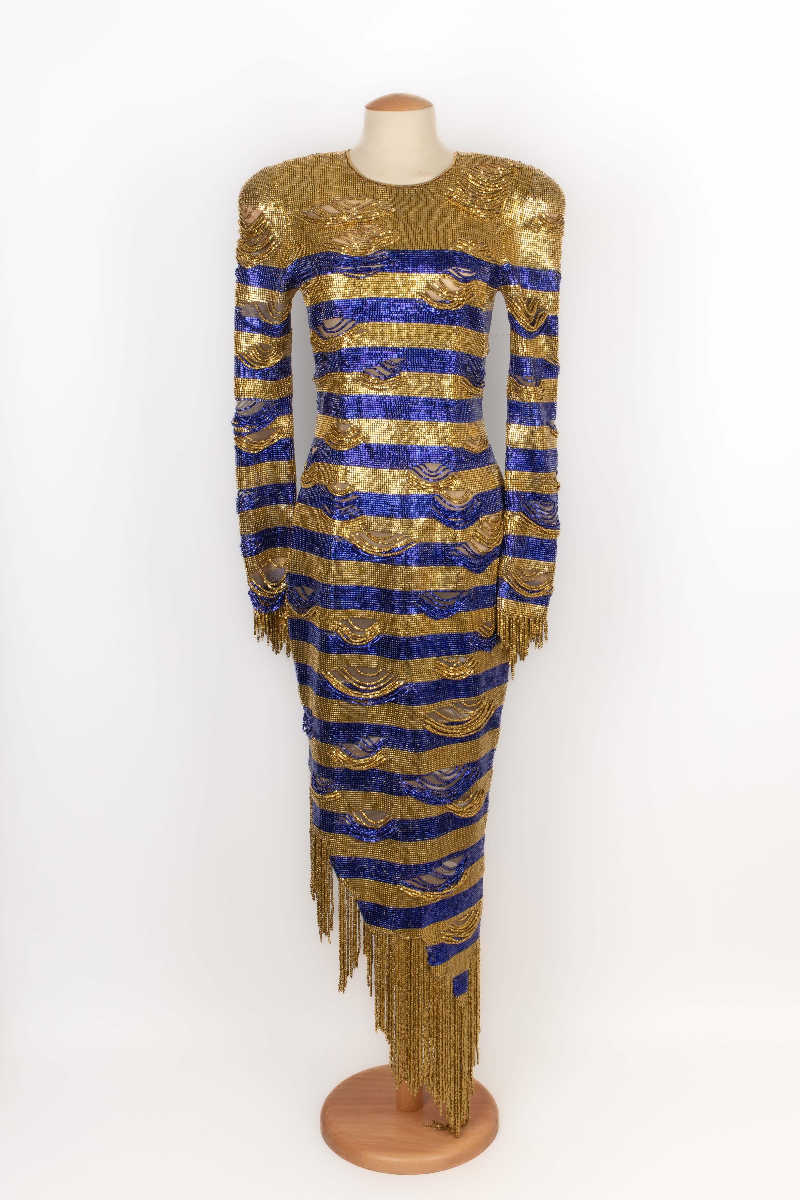 BALMAIN - 'Egyptian' dress entirely embroidered with stripes pattern made of blue and golden squared beads. Size 38FR indicated. 2023 Resort Collection under the artistic direction of Olivier Rousteing.

Condition:
Very good