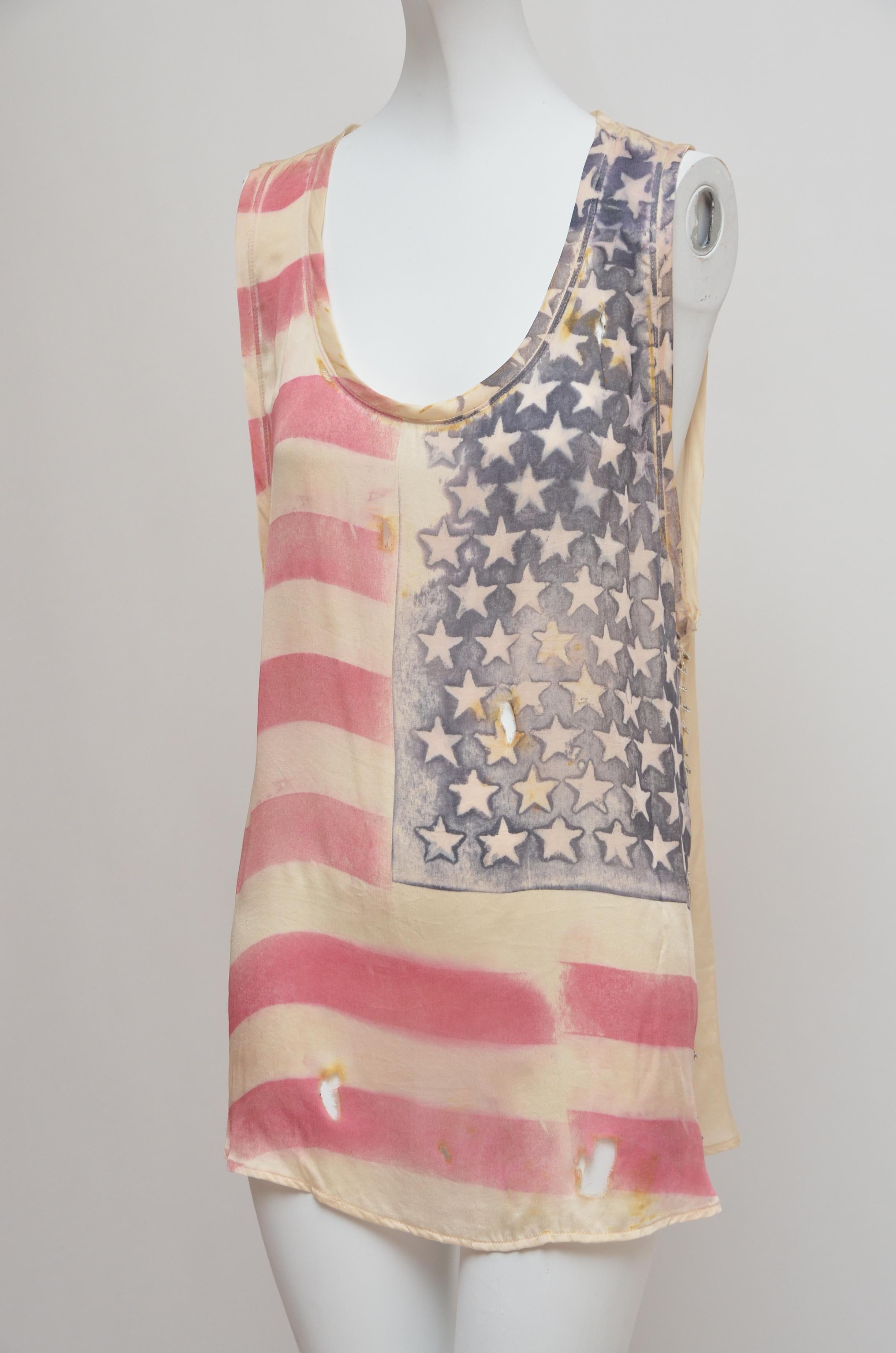 Cream silk tank with red and blue USA flag-print at front. 
Balmain tank has a scoop-neck, large armholes, side splits fastened with silver safety pins, a round hem, burn hole details and simply slips on. 
100% silk. Dry Clean. Designer Color:
