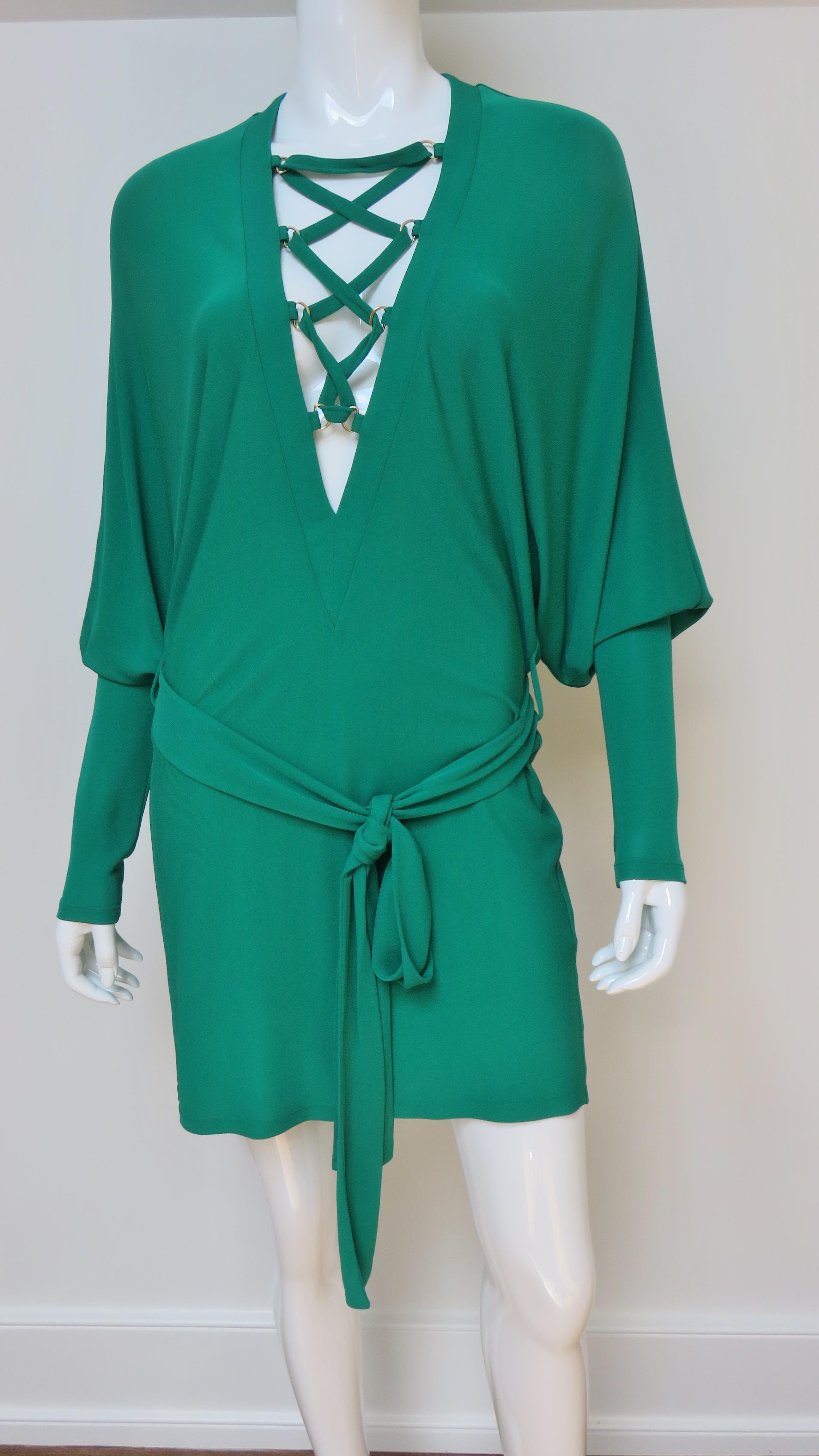 A fabulous emerald green jersey dress from Pierre Balmain.  It has a deep V front neckline with lacing detail, dolman sleeves with wide cuffs and a matching tie belt.  It drapes beautifully on the body and slips on over the head.
Fits sizes Small,