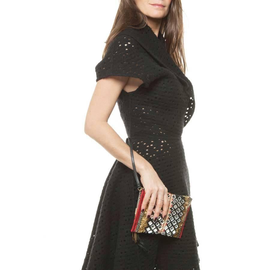 Stunning Balmain evening clutch. It is entirely handmade in Paris. Work of haute couture. Fabric in lamé gold, embroidered of multi red, gold and black ribbons and squares of mirror on a bottom of black metal mesh. 
Zip fastening with a tassel. The