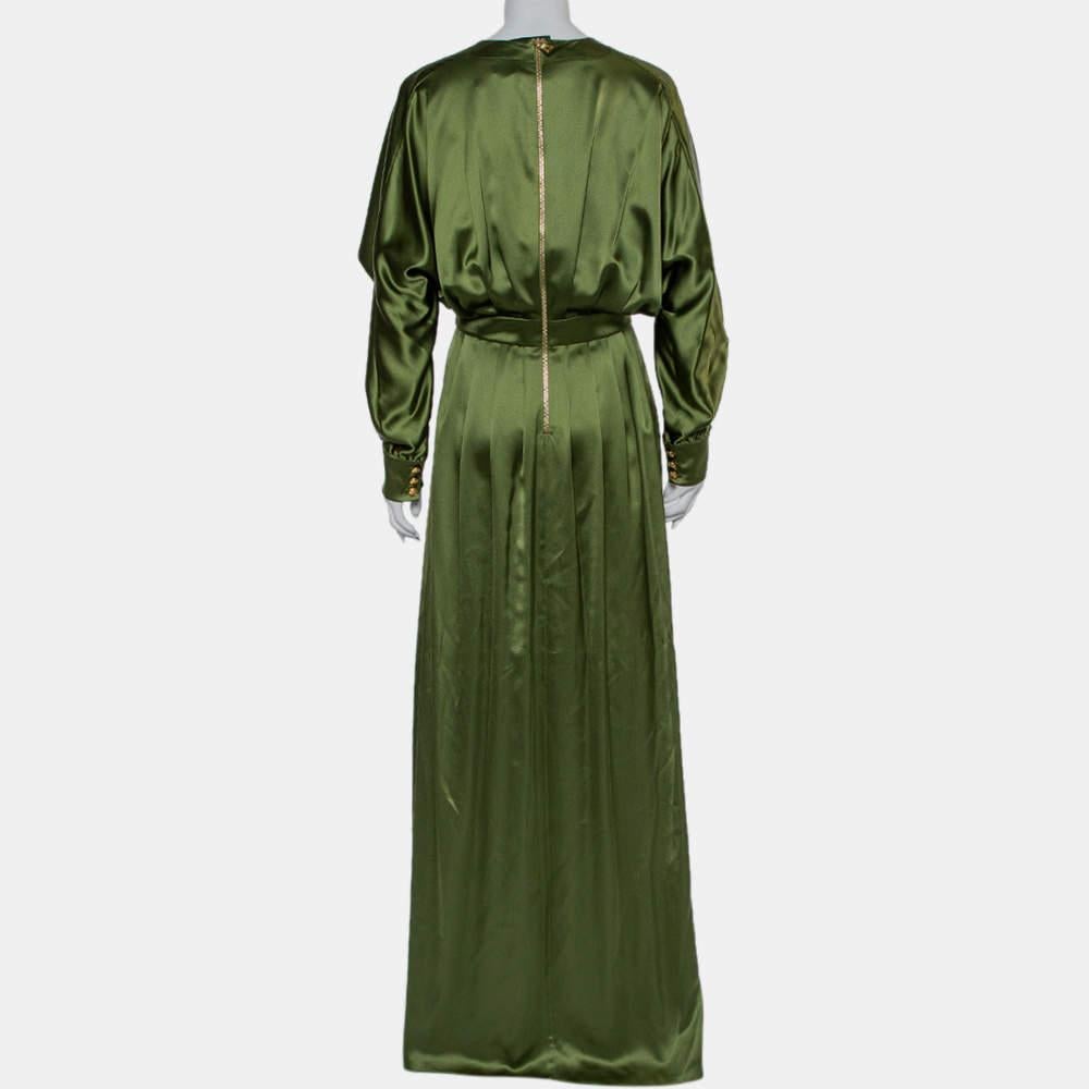 Artfully cur from luxurious silk, this ensemble by Balmain is a great choice for evenings. It comes in a lovely shade of green and is styled to maxi length. It has v-neckline, long sleeves with cuffs, a cinched waist, slit detailing and pleats. The