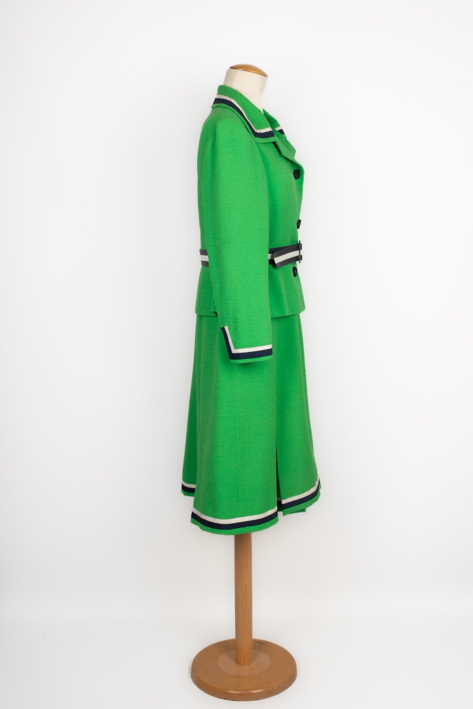 Balmain - (Made in France) Green woolen set composed of a jacket and a dress, and with navy-blue and white large grain trimmings with braids. Missing size and composition labels, it fits a 38FR.

Additional information:
Condition: Very good