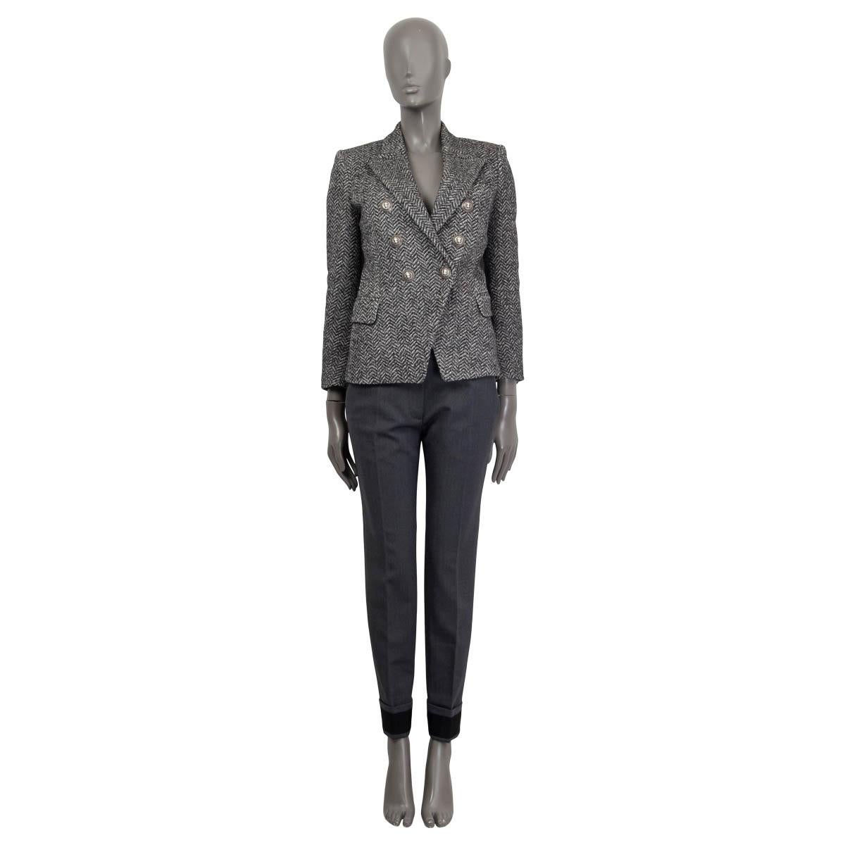 100% authentic Balmain double-breasted herringbone blazer in black and white cotton (52%) and wool (40%) tweed with a slim-fitting silhouette, one sewn shut patch pocket on the chest, two flap pockets and buttoned cuffs. Closes with embosses logo