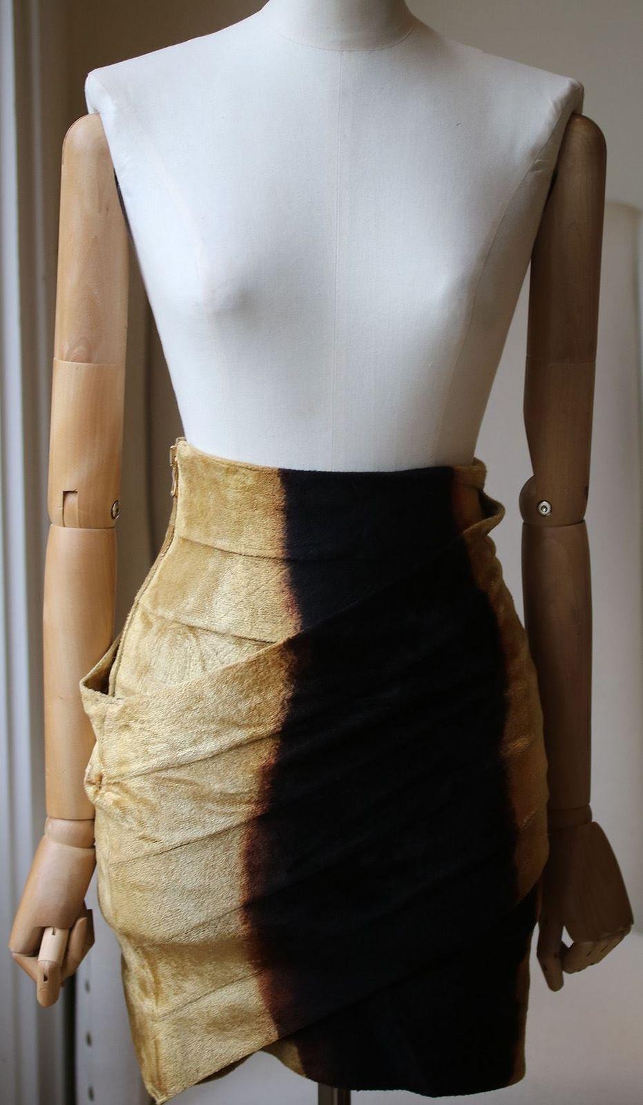 Glamorous bodycon mini skirt in an alluring colorway. Exposed goldtone back zip closure. Contrast hip panels. About 20