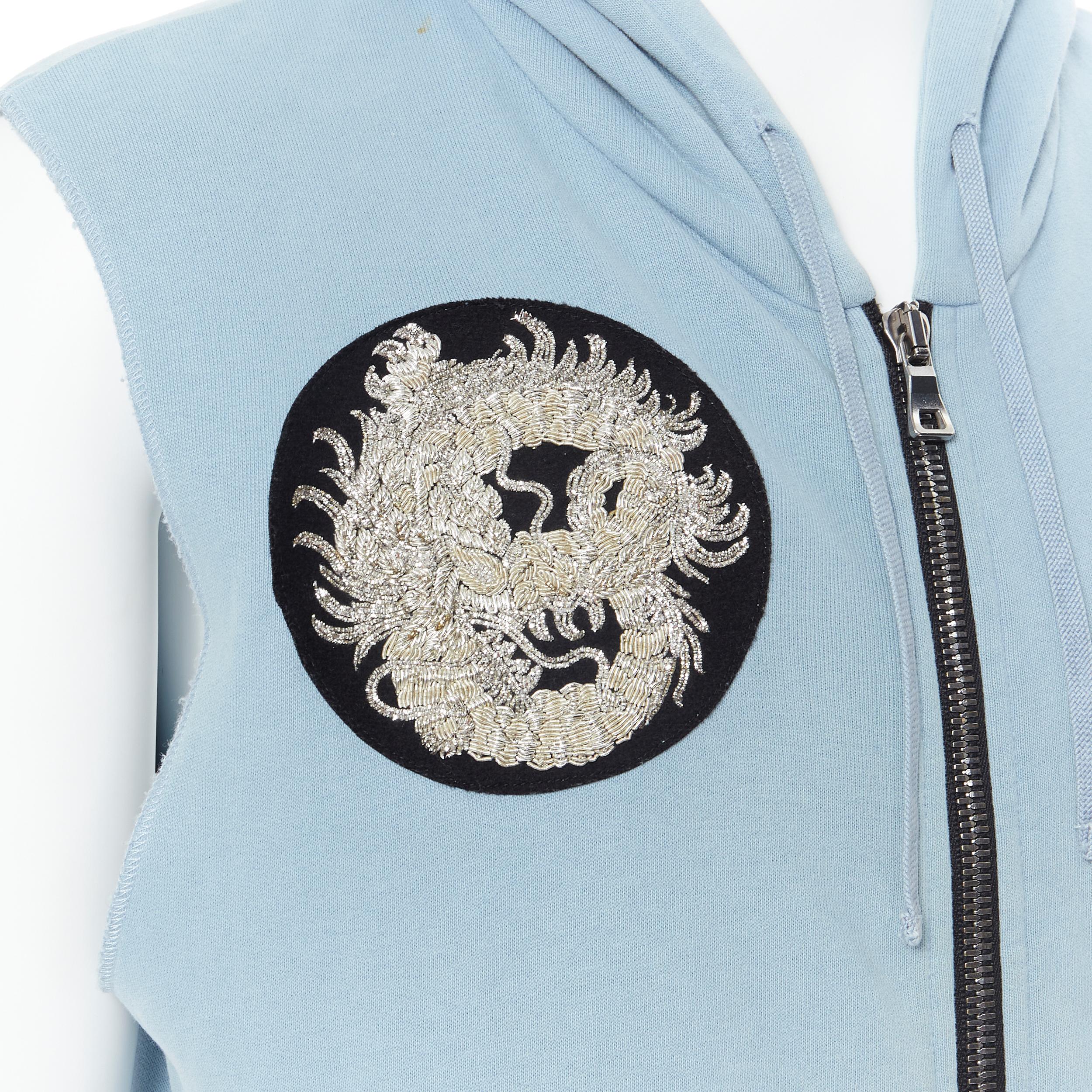BALMAIN light blue cotton raw cut embroidery patch heavy zip hooded vest M 
Reference: TGAS/B00214 
Brand: Balmain 
Designer: Olivier Rousteing 
Material: Cotton 
Color: Blue 
Pattern: Solid 
Closure: Zip 
Extra Detail: Zip front closure. Zip side