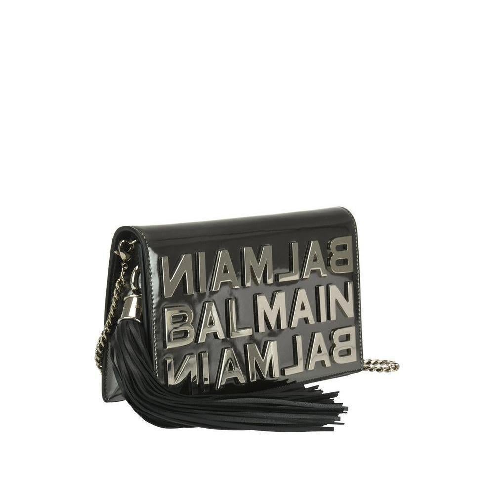 The Balmain clutch is bright, elegant and distinctive.The silver metallic letters are applied on the shiny black leather bottom, shaping the brand.The overflap with magnet closure, the removable silver chain shoulder strap and the black leather