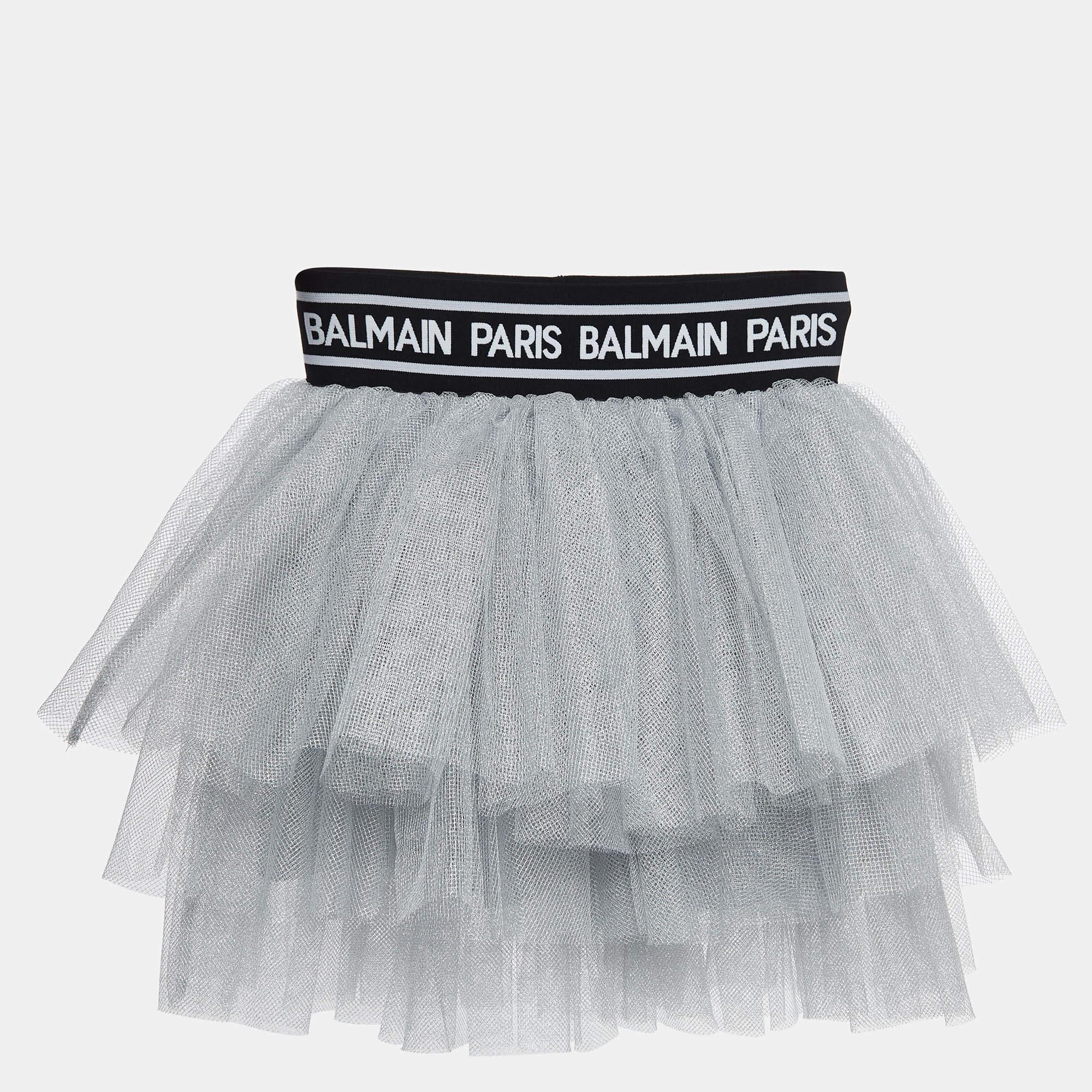 The Balmain skirt is a charming and stylish garment. Crafted with shimmering silver fabric the tiered tulle layers add a playful touch. This cute skirt showcases Balmains iconic design creating a delightful and fashionable addition to any little