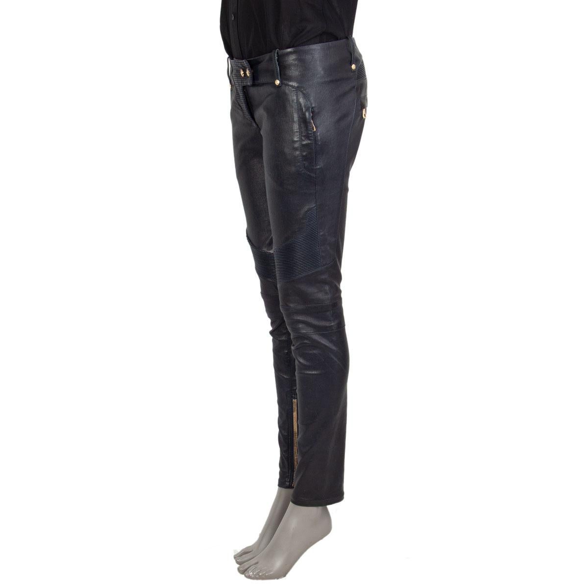 100% authentic Balmain biker pants in midnight blue lambskin with gold tone eagle embossed buttons, front zipper pockets, back zipper pockets and cuff zippers. Close on the front with a zipper and buttons. Doublure is cotton (100%). Have been worn