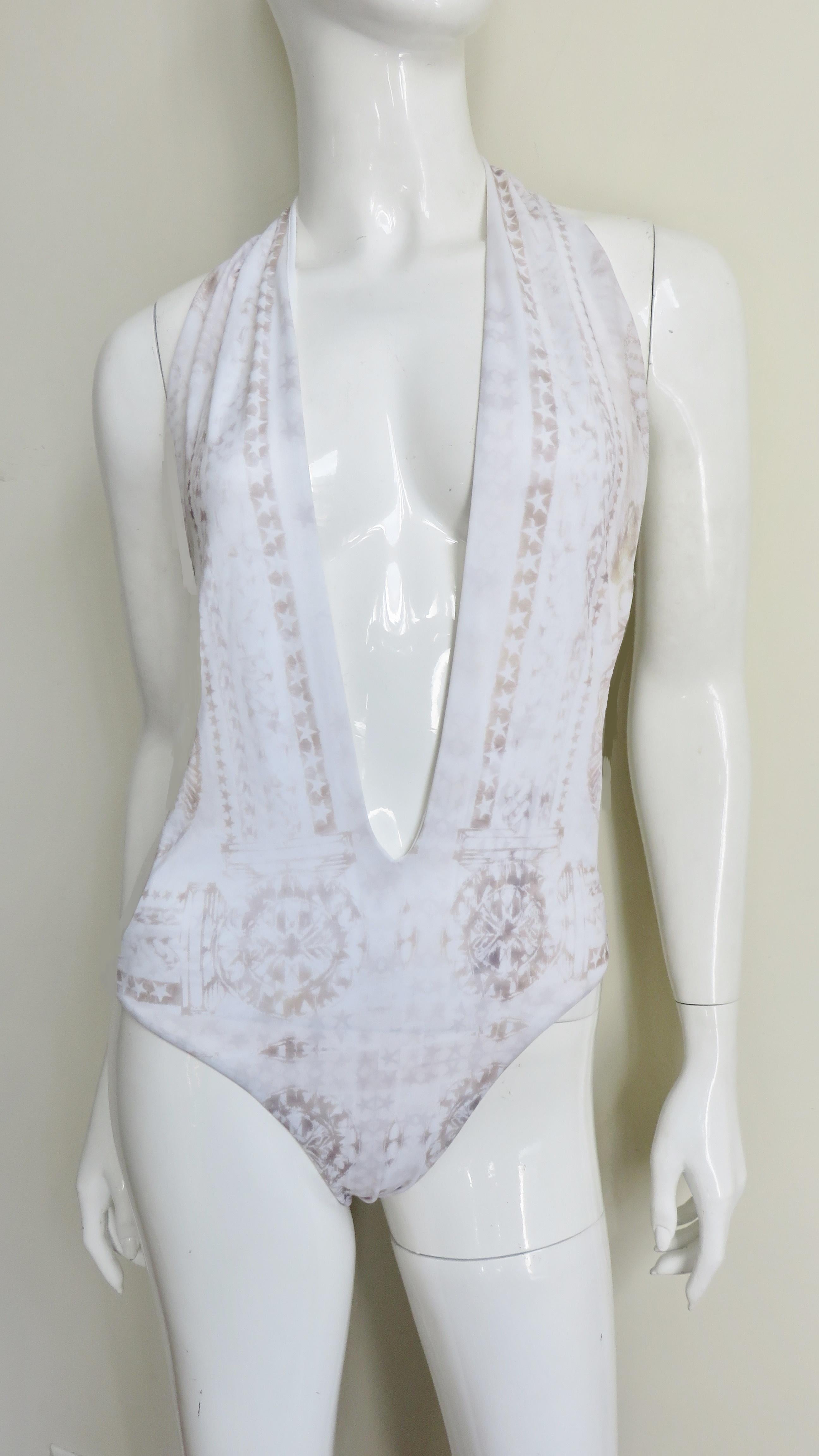 A fabulous plunging front swimsuit in white with a grey abstract geometric pattern from Pierre Balmain.  It has a low plunging neckline closing at the back of the neck with a gold metal clasp and ties at the side bust.
New with tags unworn