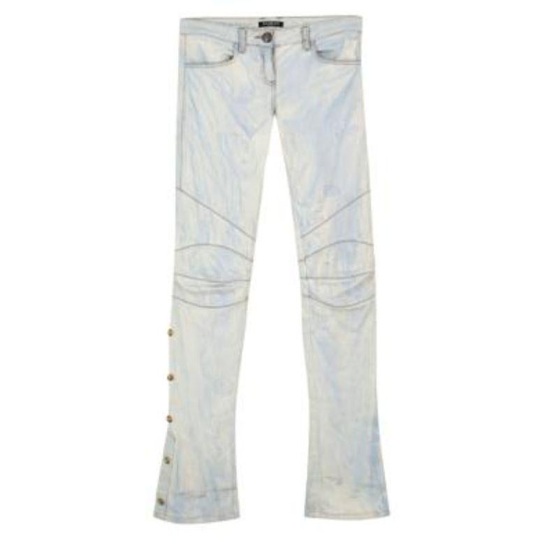 Balmain Light Blue Washed Denim Flared Jeans 
- Washed/tie die effect denim
- Slight distressing 
- Patterned stitching at knees 
- Slight flare at the bottom
- Gold toned buttons along the sides of the legs
- Silver toned Balmain branded button 
-