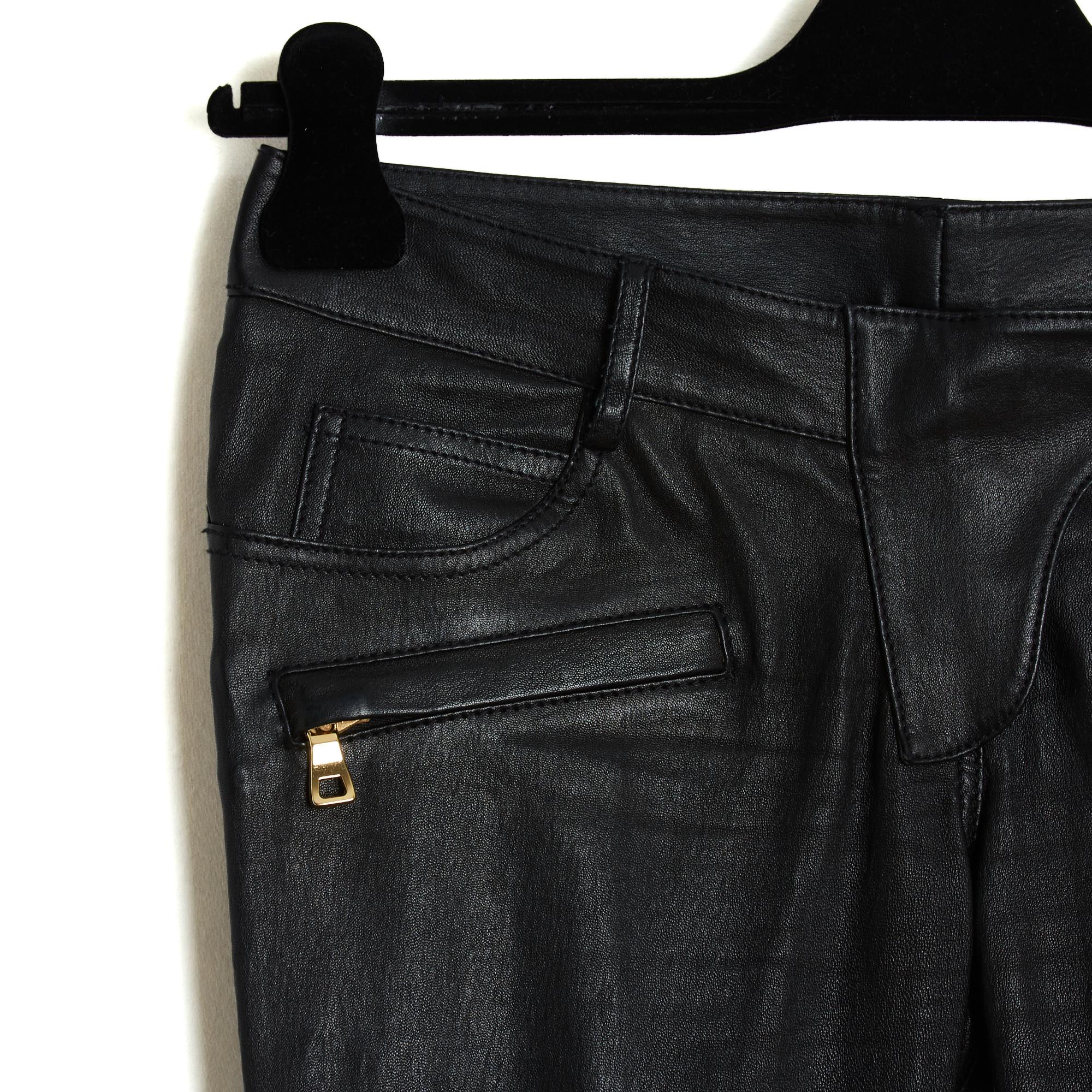 Schwarze Stretch-Lederhose von Balmain mit schmaler Passform, niedriger Leibhöhe, zwei Vordertaschen und zwei Gesäßtaschen, die durch einen goldfarbenen Metallreißverschluss gesichert sind. Passende Reißverschlüsse an den Beinöffnungen. Größe FR 36