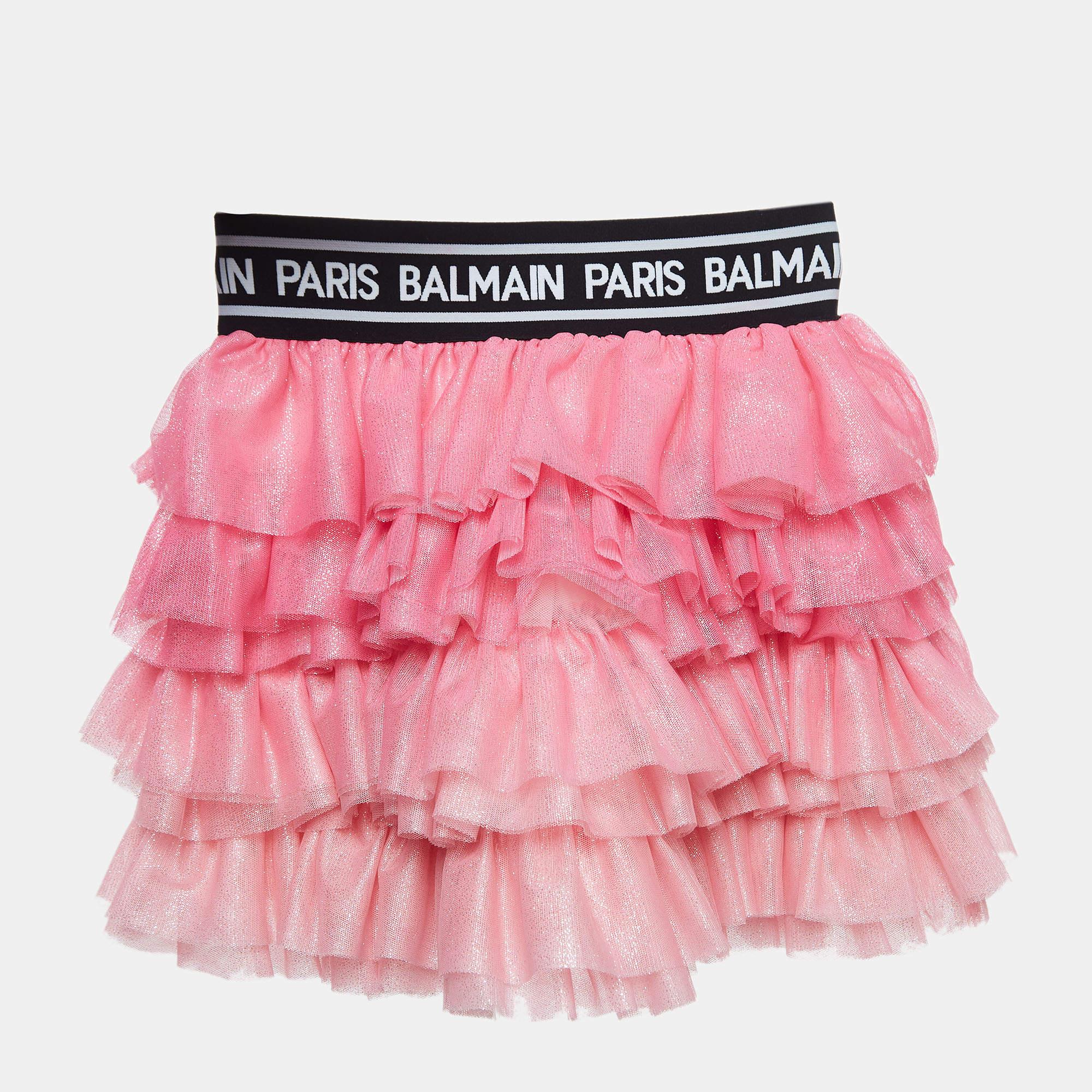 The Balmain skirt is a charming and stylish garment. Crafted with shimmering pink fabric the tiered tulle layers add a playful touch. This cute skirt showcases Balmains iconic design creating a delightful and fashionable addition to any little ones