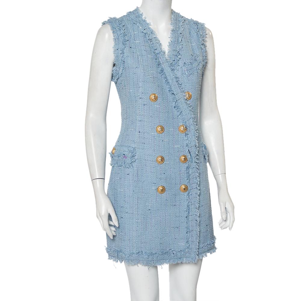 A powder blue tweed dress by Balmain that you can effortlessly match with statement sandals, pumps or booties. Created in a sleeveless style, the mini dress brings a double-breasted front with gold-tone button details, two pockets, and a back zip