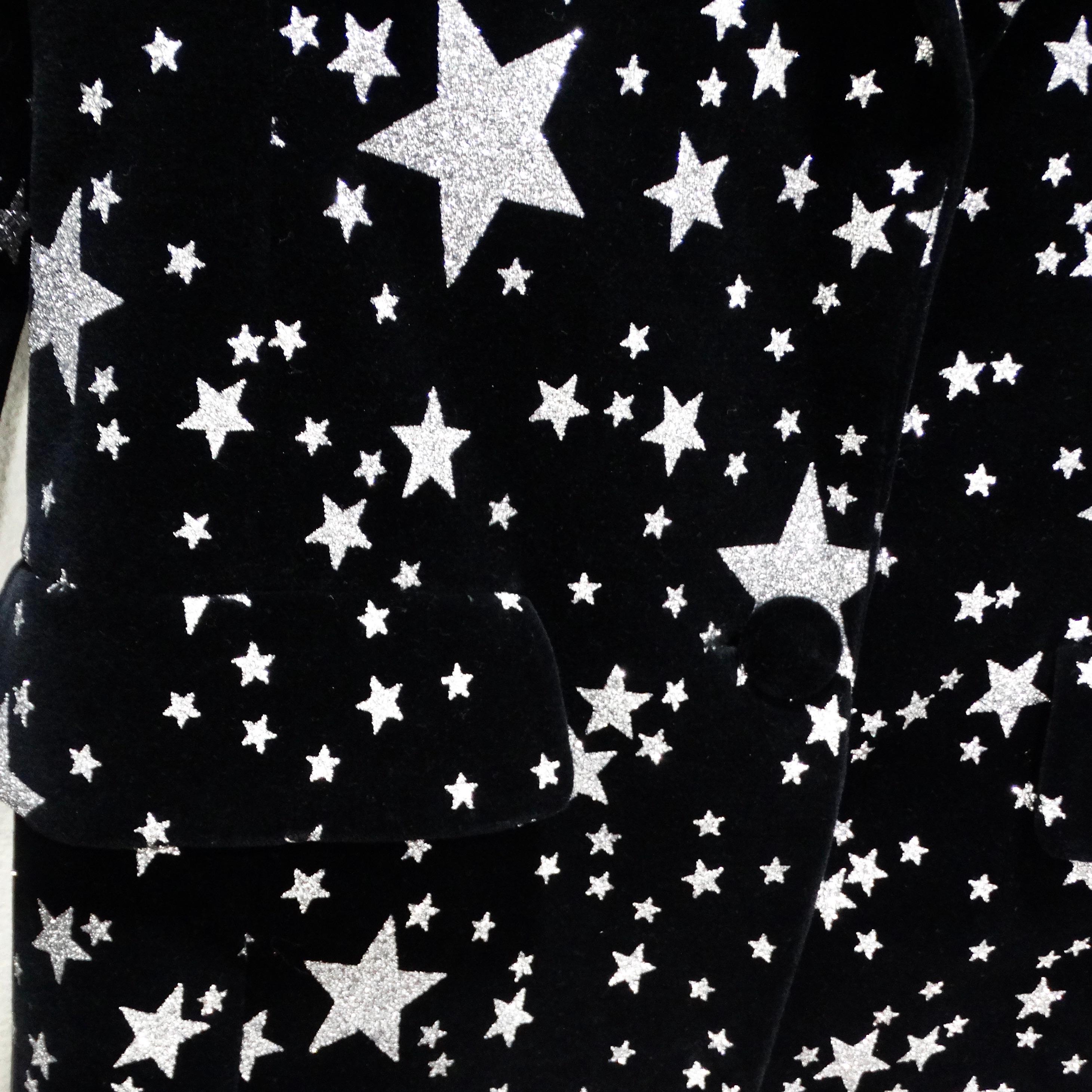 Voici le blazer à épaules larges imprimé étoiles de Balmain Pre Fall 2021, une pièce moderne et chic, qui respire la sophistication et le style. Confectionné dans un luxueux velours noir, ce blazer est orné d'étoiles argentées qui scintillent et