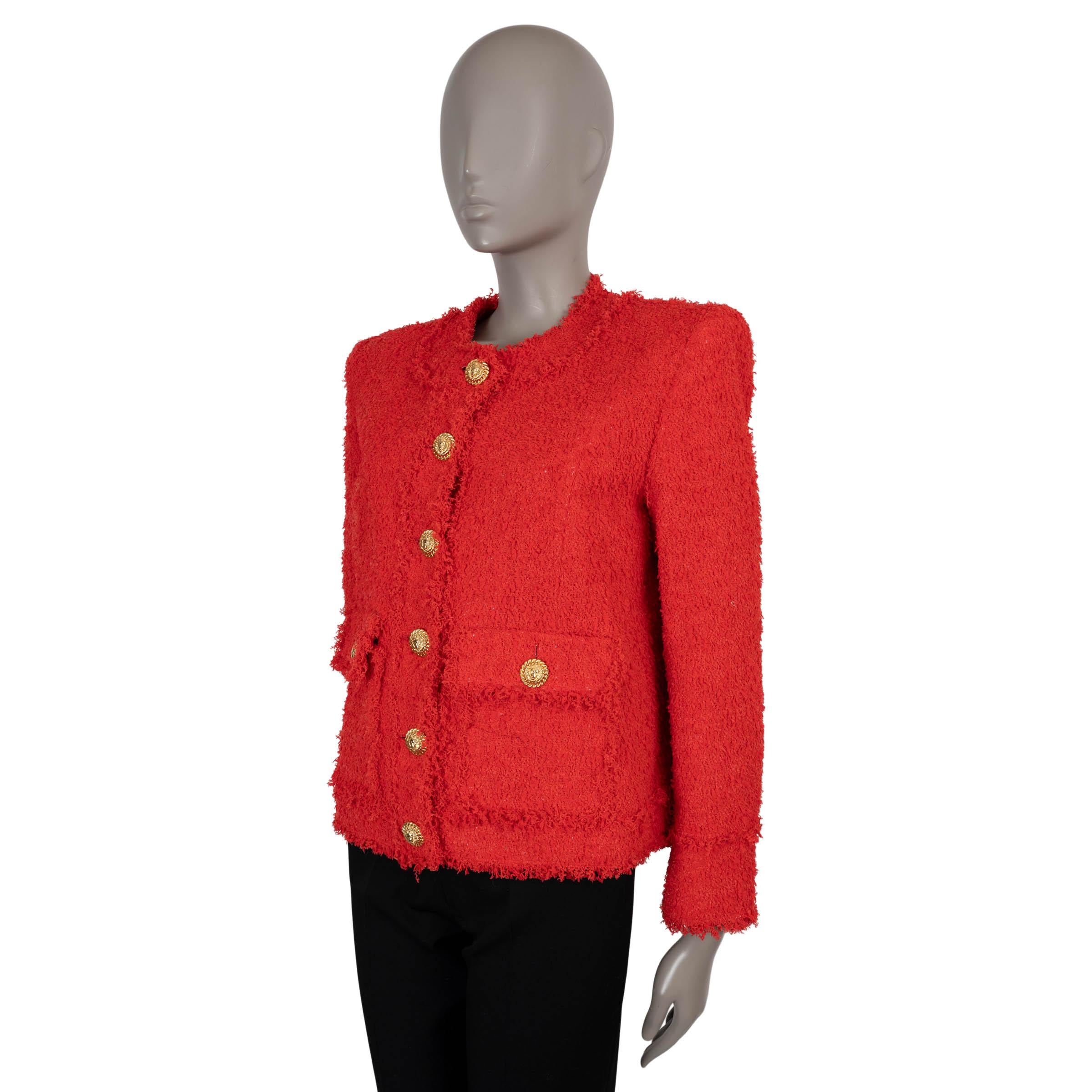 This 100% authentic Balmain jacket is crafted from vibrant red tweed made of polyamide (100%). It features a collarless, cropped boxy silhouette with a crew neckline and structured shoulders. The design includes two front flap pockets adorned with