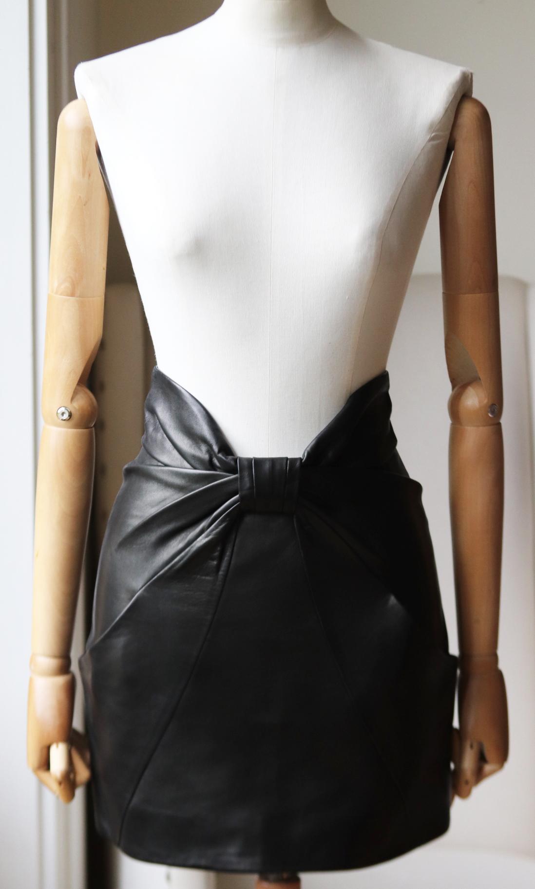 Dieser Rock von Balmain wurde für eine feminine und doch kantige Silhouette mit butterweichem Design gefertigt und verfügt über eine schleifenförmige Rüsche an der Taille sowie verdeckte schräge Taschen. 
Schwarzes Leder. 
Reißverschluss hinten.