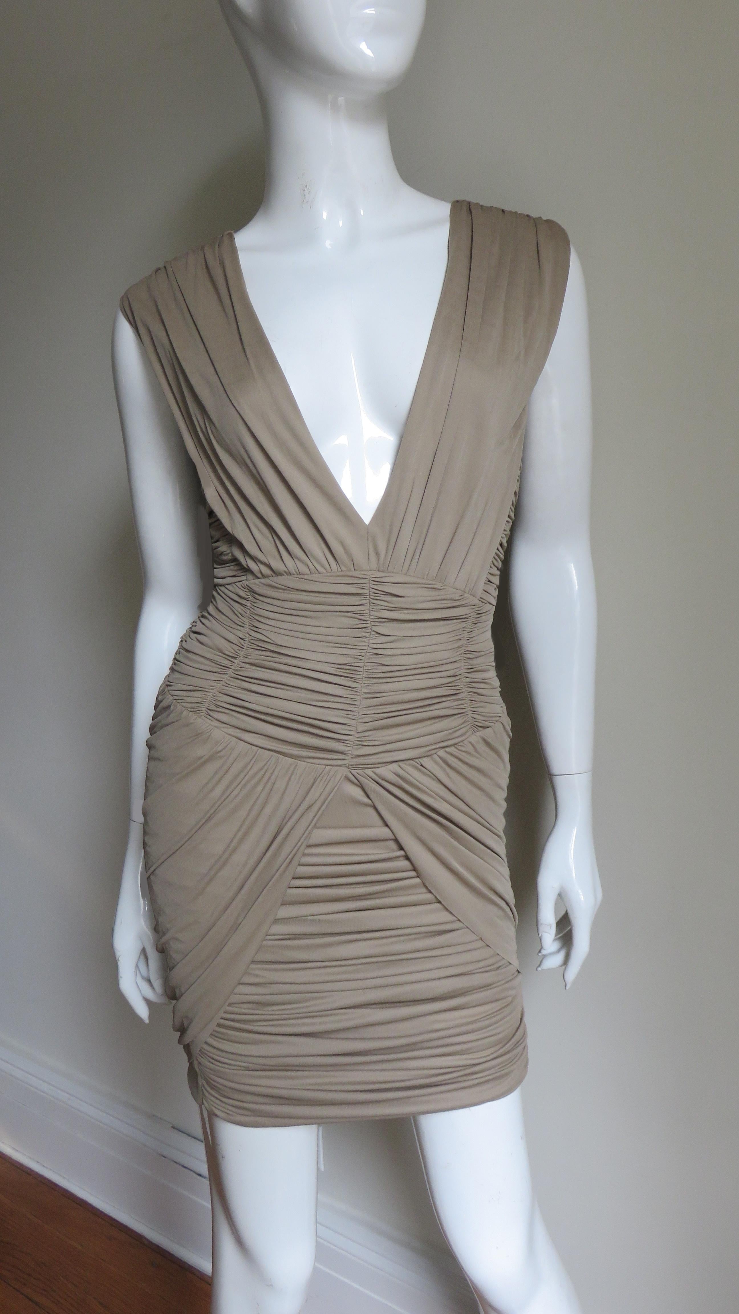 A fabulous taupe fine silk jersey dress from Balmain.  It has a plunging neckline framed by shoulder to waist length ruched panels.  The waist is fitted with horizontally ruched panels and there is draping on either side of the horizontally ruched