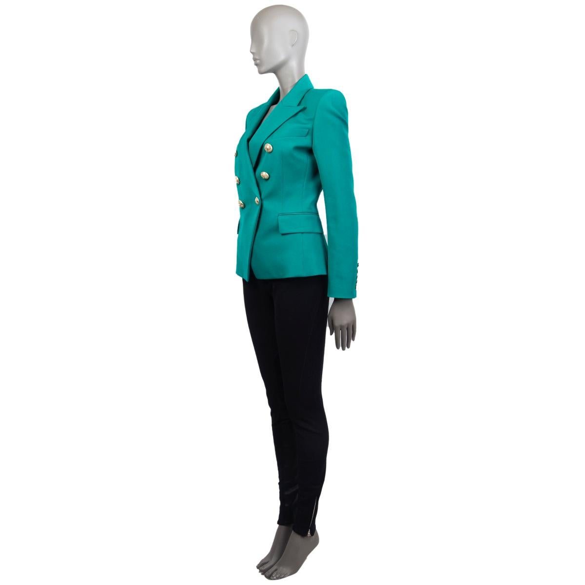 Balmain signature double-breasted blazer in sea wool (100%) with a slim-fitting silhouette, one patch pocket on the chest, two flap pockets and buttoned cuffs at the back. Closes with embosses logo gold-tone buttons in the front. Lined in malachite