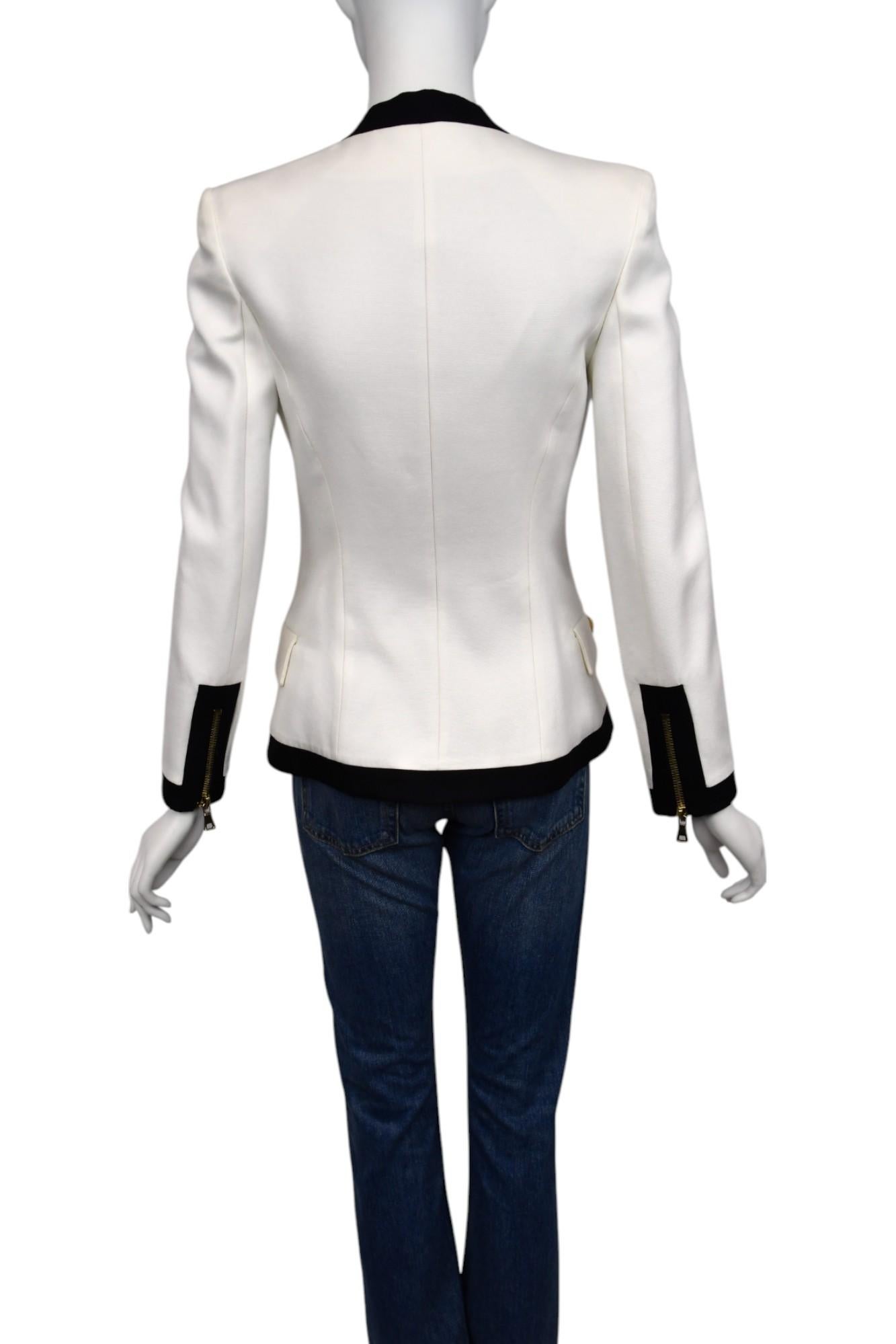 Questo blazer di Balmain unisce un taglio sartoriale deciso ad audaci accenti di contrasto, realizzato in un tessuto bianco e brillante con finiture nere lungo la scollatura, l'orlo e i polsini. Caratterizzato dal caratteristico design a doppio