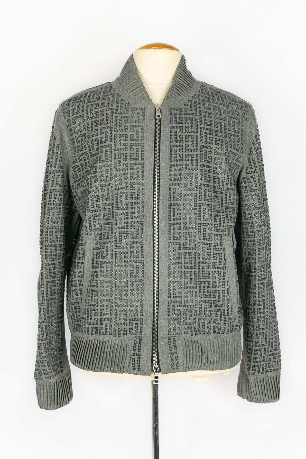 BALMAIN - (Made in Italy) Graue Bomberjacke aus Wolle mit strassbesetztem Monogramm. Keine Größenangabe, es passt eine XL. A 2021 Collection'S, unter der Leitung von Olivier Rousteing.

Bedingung:
Sehr guter Zustand

Abmessungen:
Schulterbreite 50