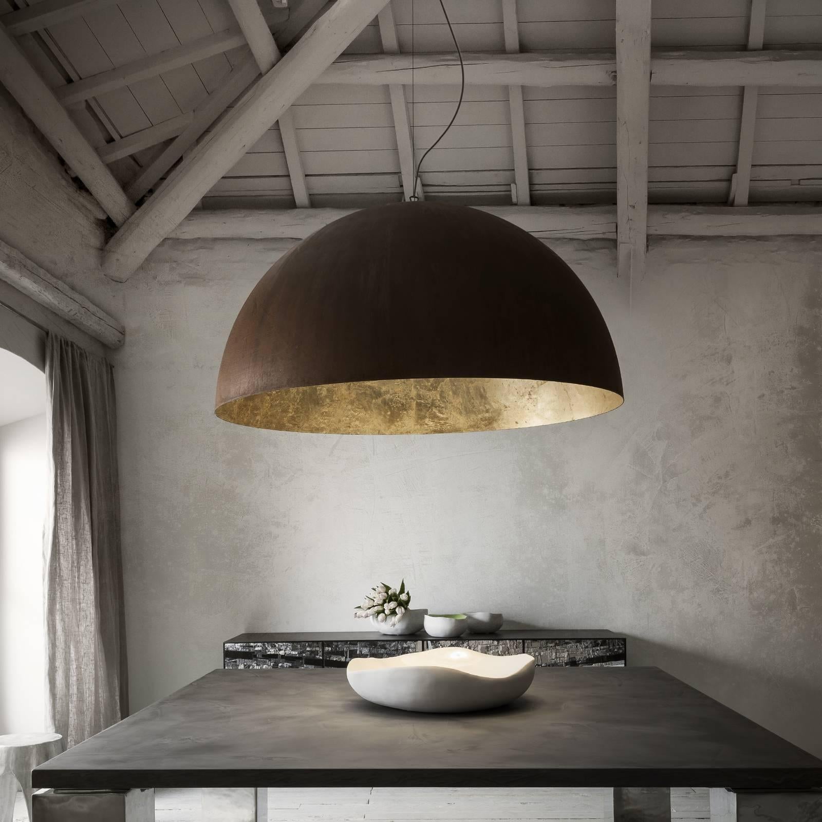 Questa lampada a sospensione in metallo diffonderà un calore senza tempo e un'aura di calma in qualsiasi salotto o sala da pranzo dallo stile moderno o rustico. Realizzato in metallo con finitura Corten, l'interno del paralume semicircolare è