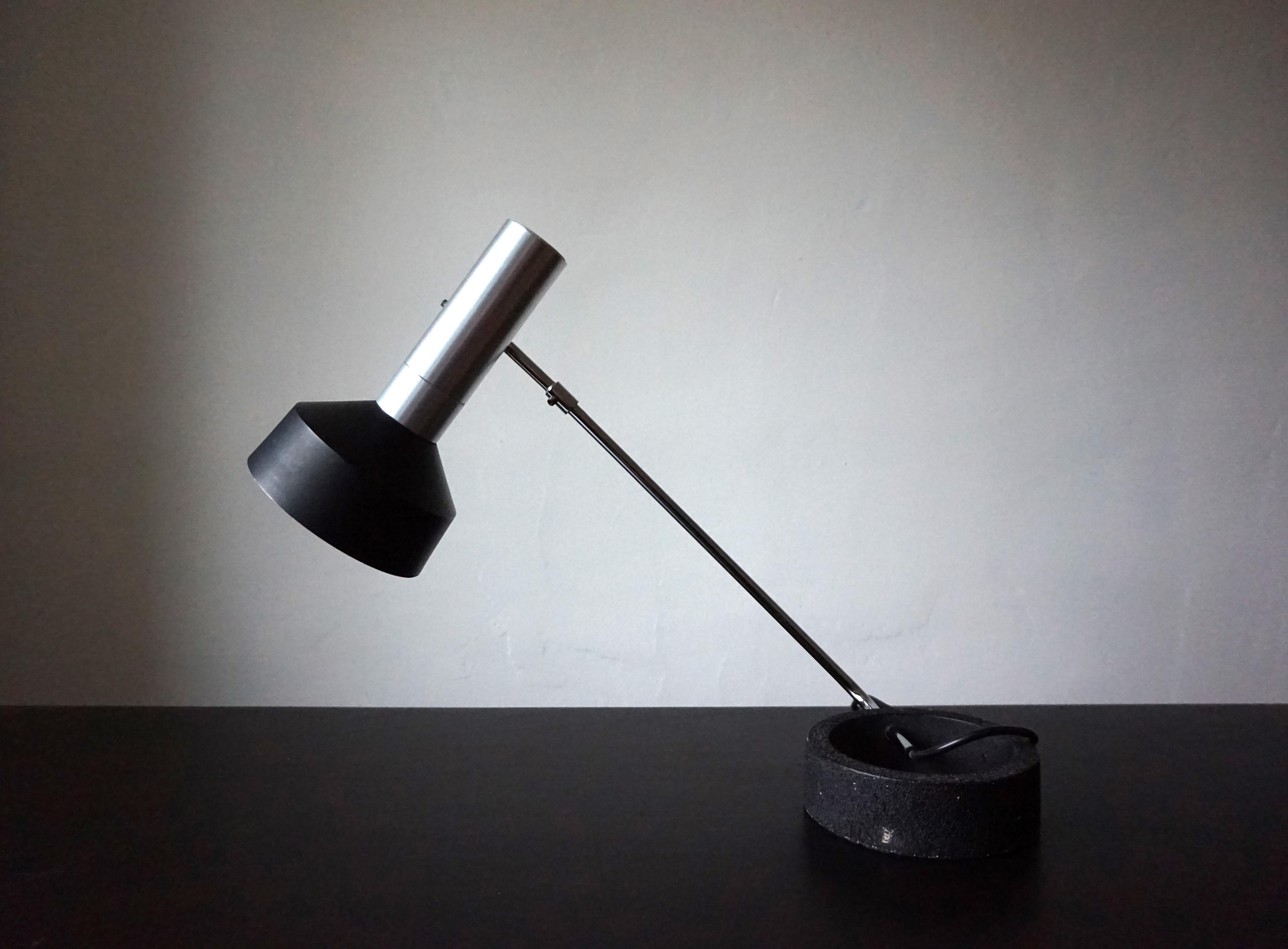 Una lámpara de mesa Baltensweiler Minilux que sigue impresionando hoy en día por su estética minimalista. El foco cilíndrico de aluminio cepillado y pantalla negra, de diseño claro, está en excelentes condiciones. El interruptor pulsador está oculto