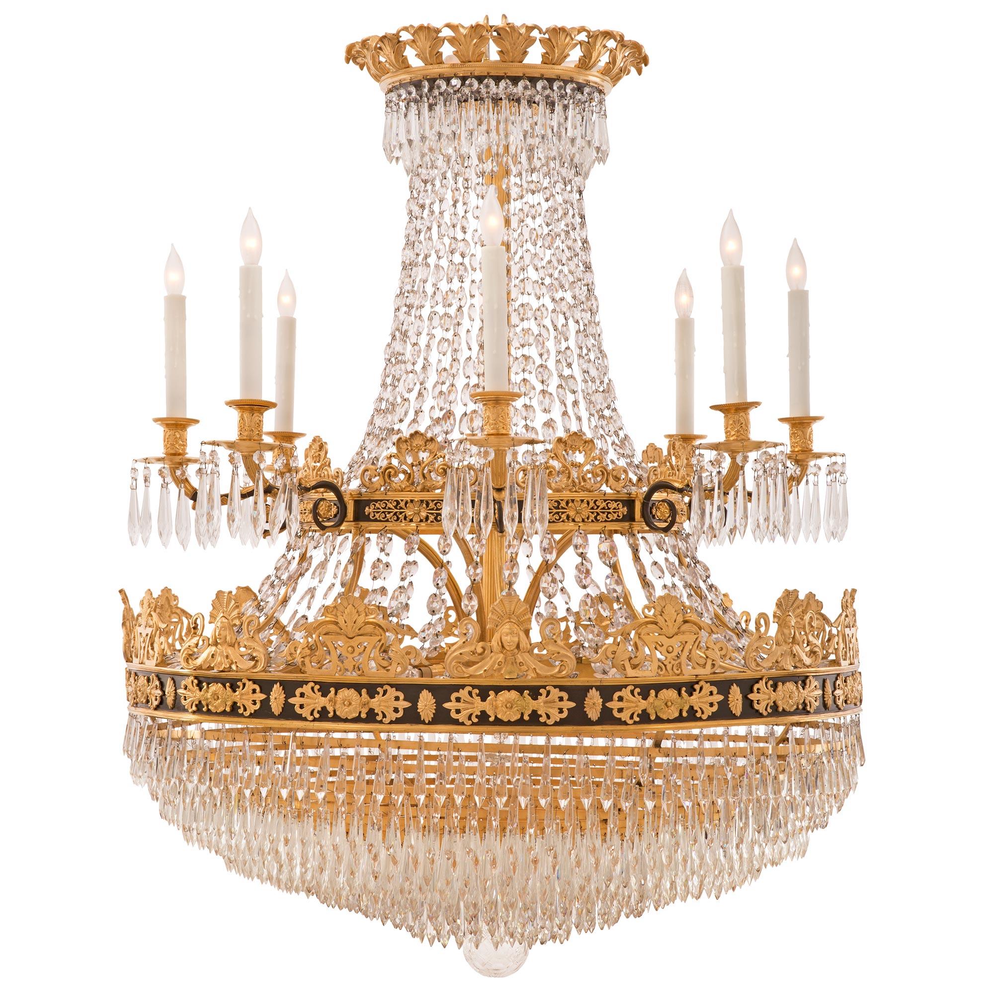 A stunning and extremely high quality Baltic 19th century Empire st. ormolu, patinated bronze and crystal chandelier. The two tiered eight arm twenty four light chandelier is centered by a beautiful bottom crystal ball with a lovely and uniquely cut
